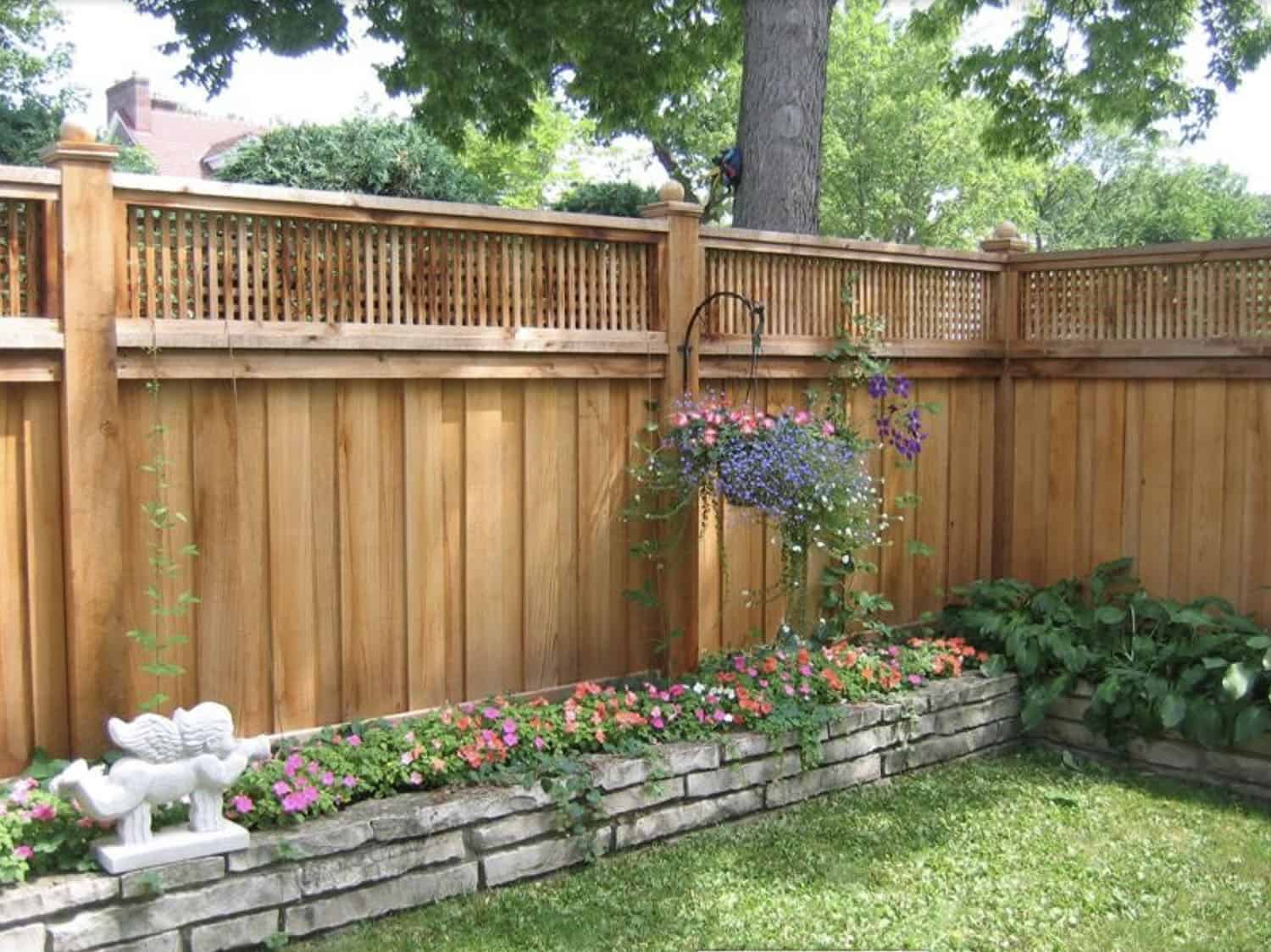 raised brick flower bed with a cedar fence