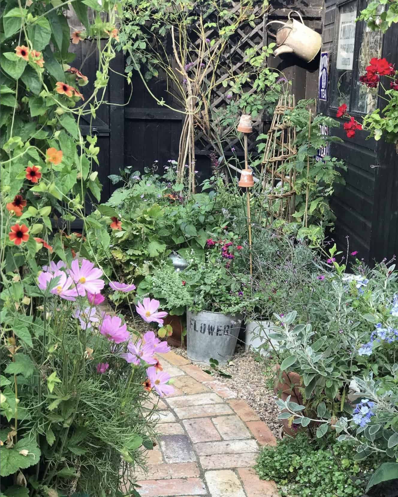 small corner garden with a brick walkway