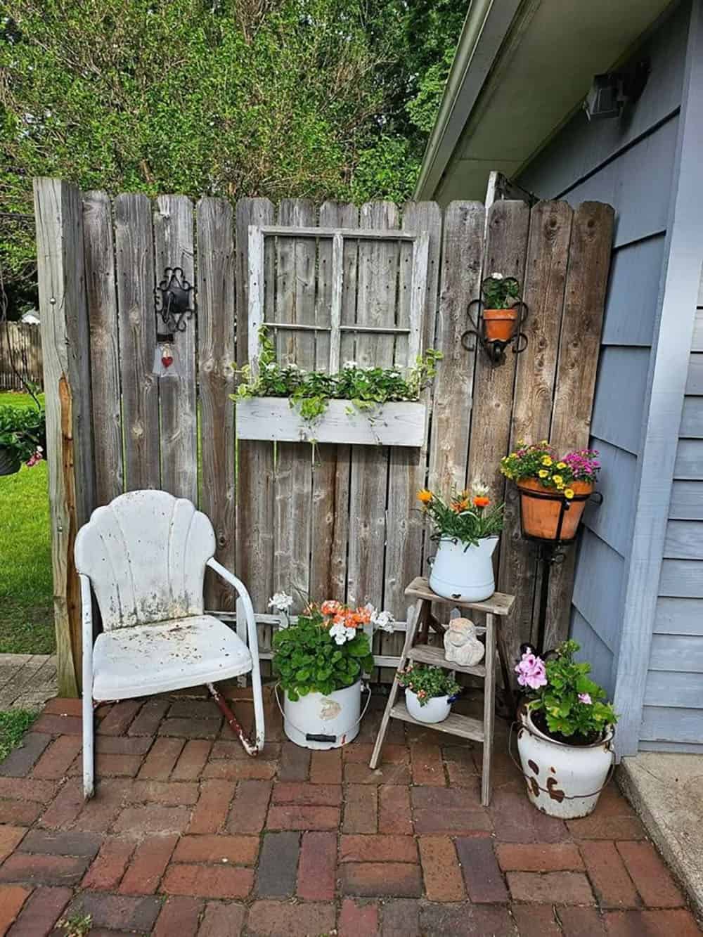 corner garden with a wood divider wall and container plants