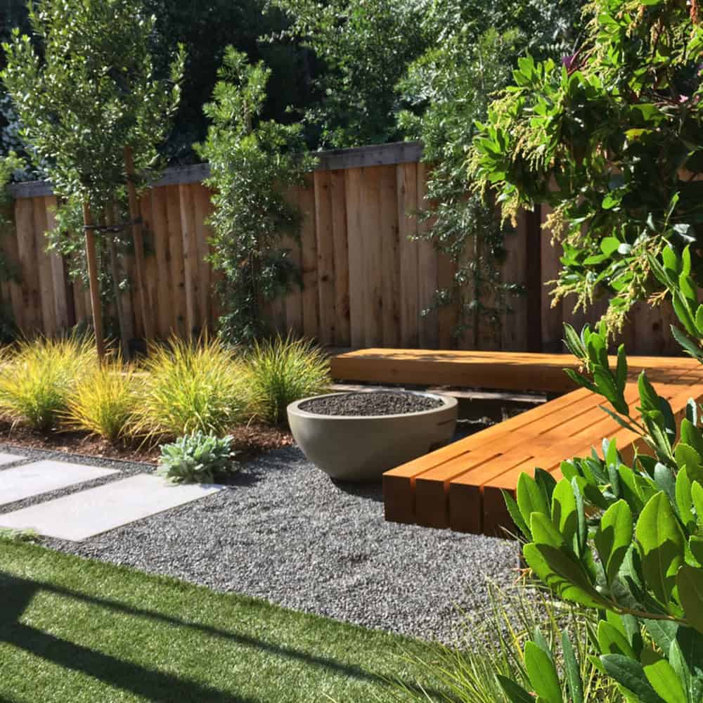 small backyard garden with a built-in bench and fire pit