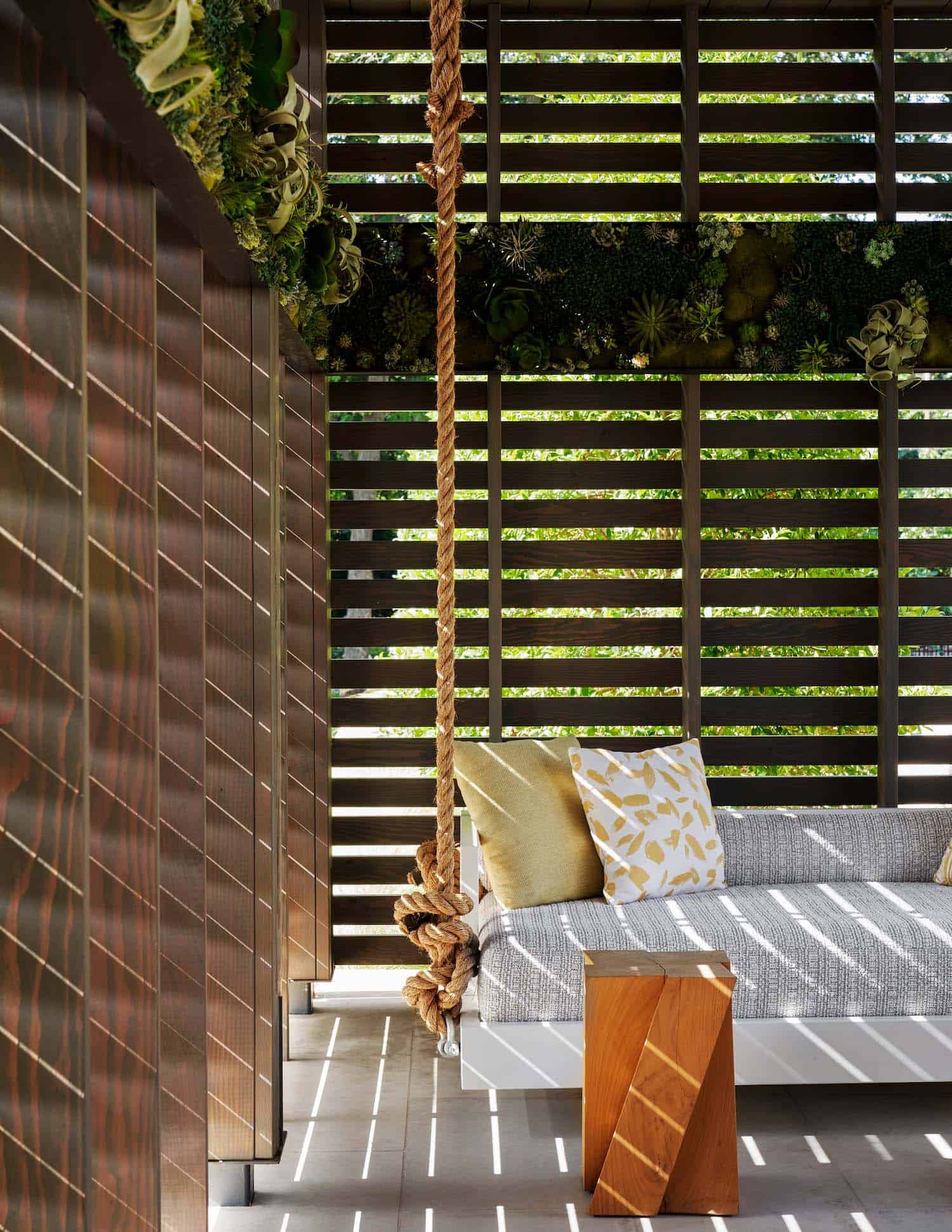 contemporary home covered patio with a hanging daybed