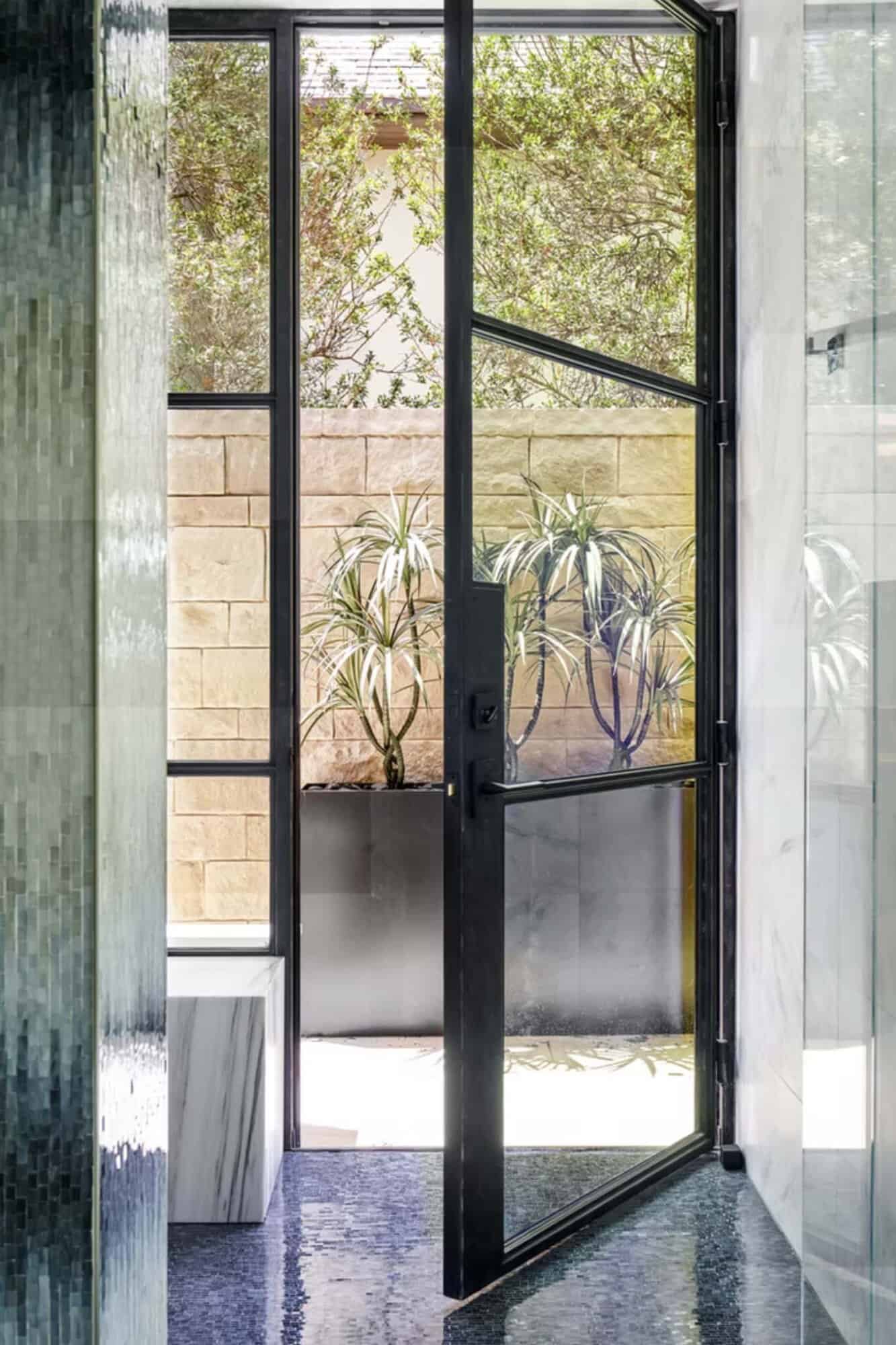 contemporary home entry with a glass and steel door