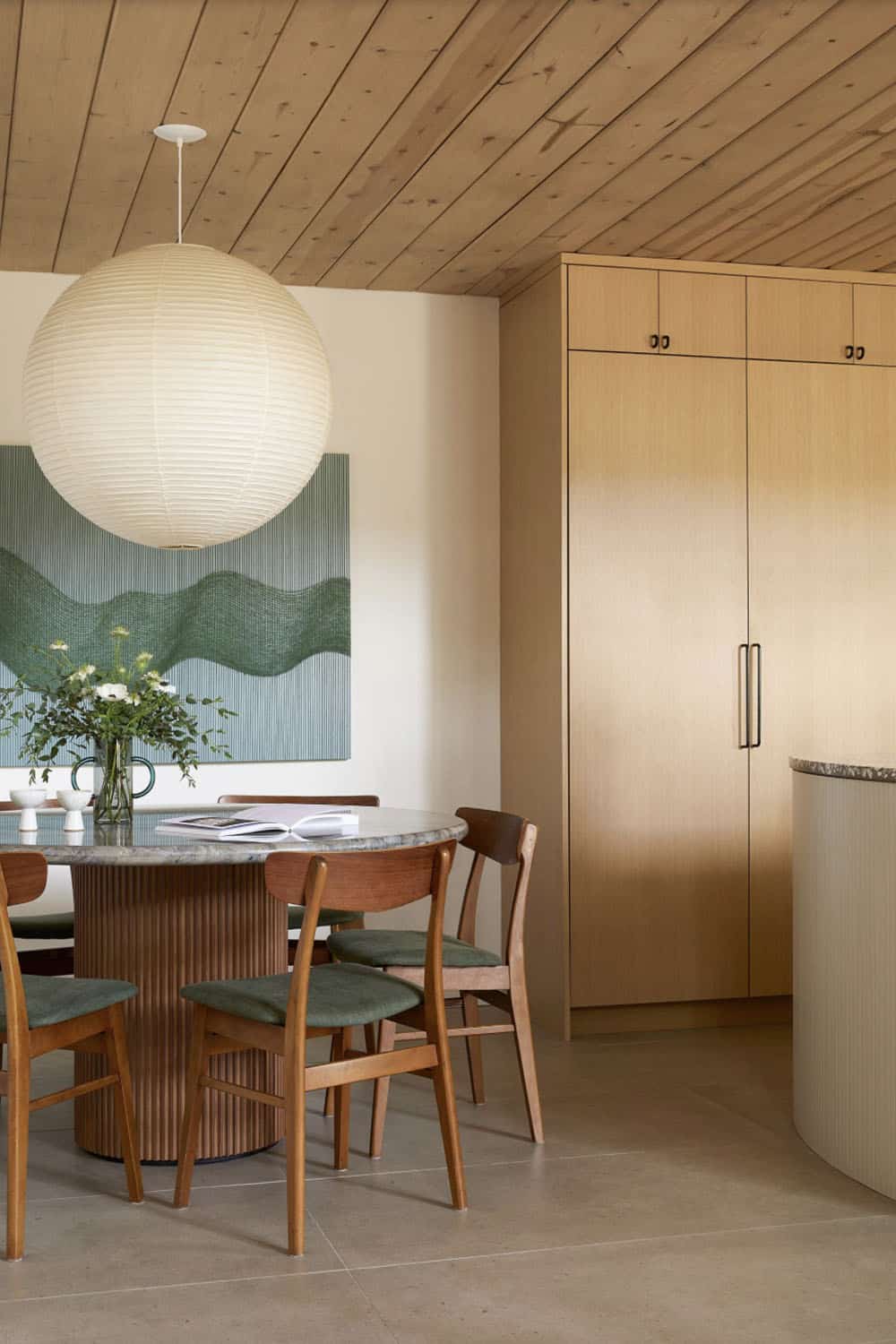 A dining room with a round table and chairs