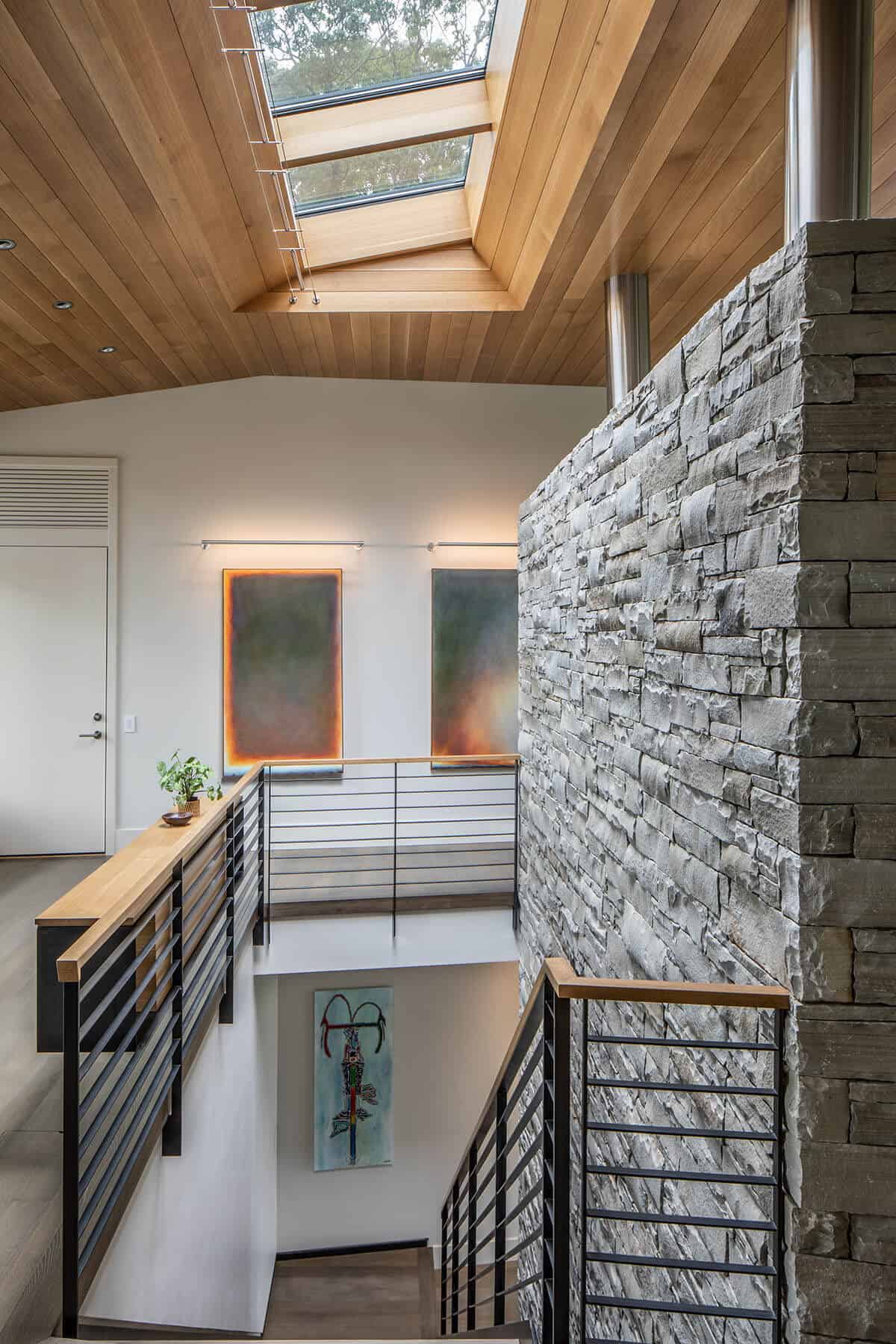 rustic modern staircase with a stone accent wall