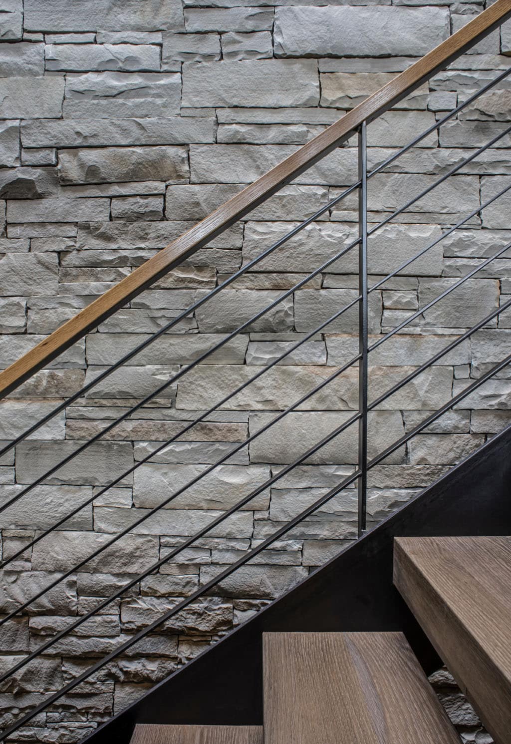 rustic modern staircase with a stone accent wall