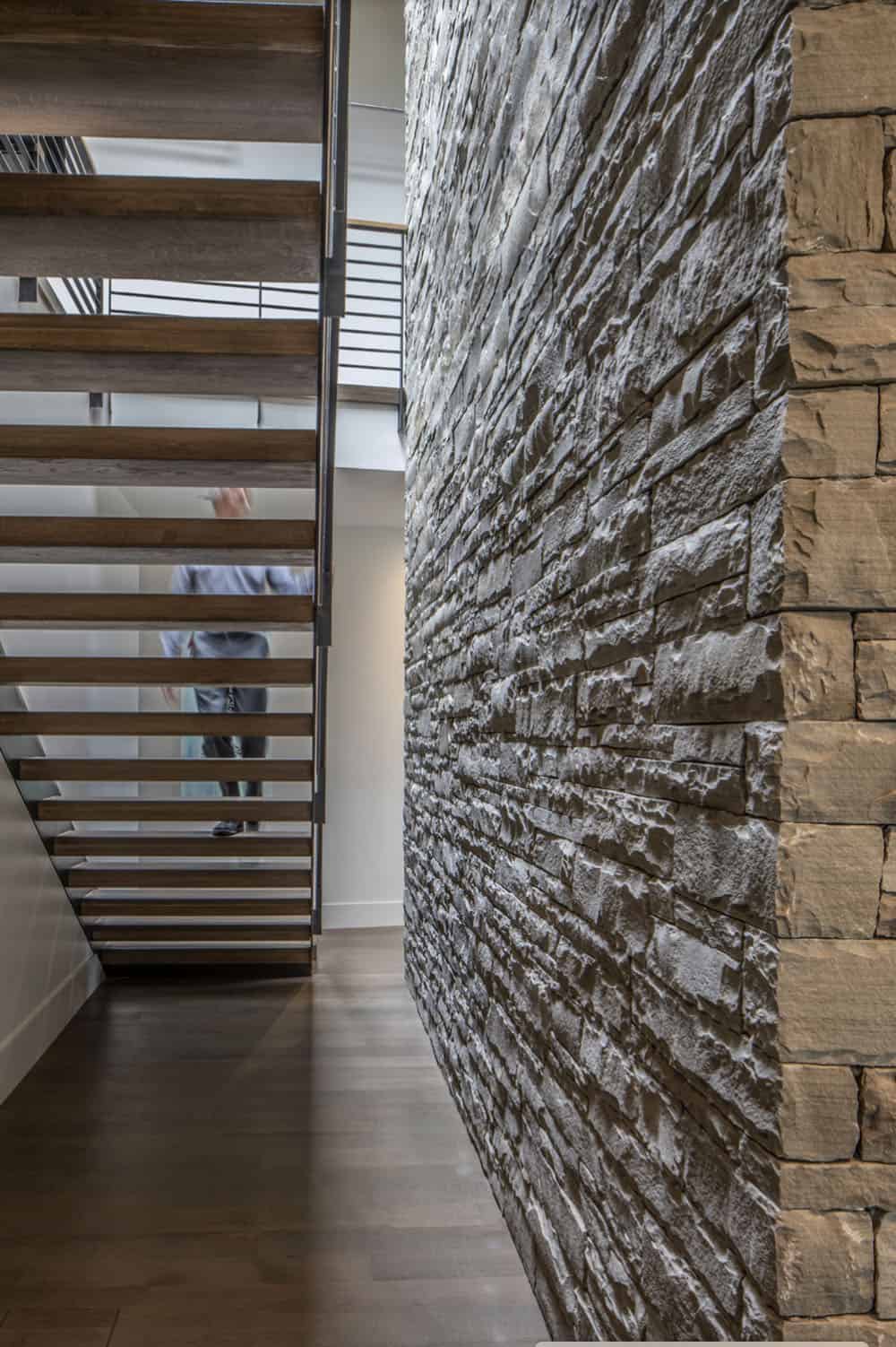 rustic modern staircase with a stone accent wall