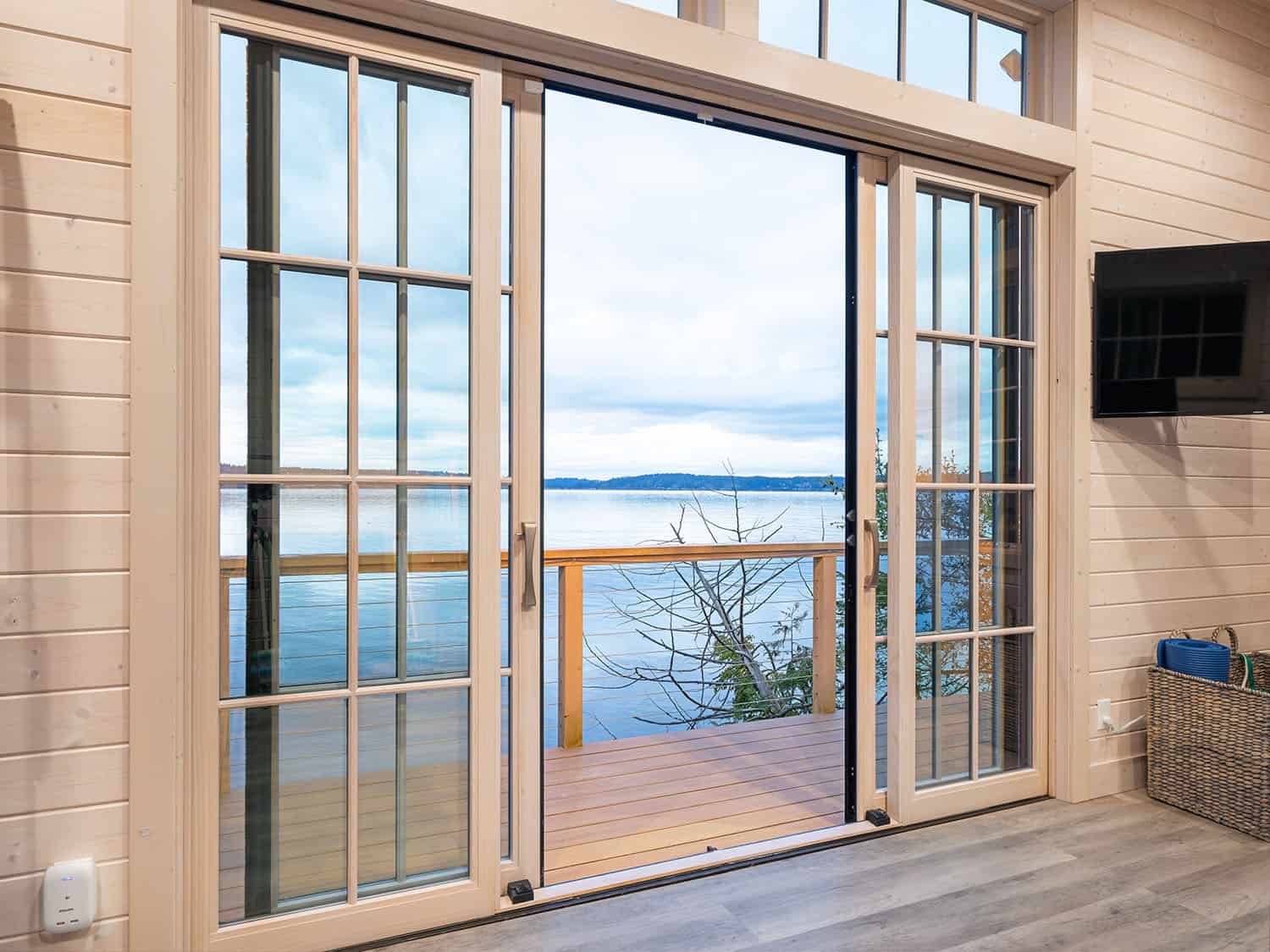 modern home gym with french doors with water views