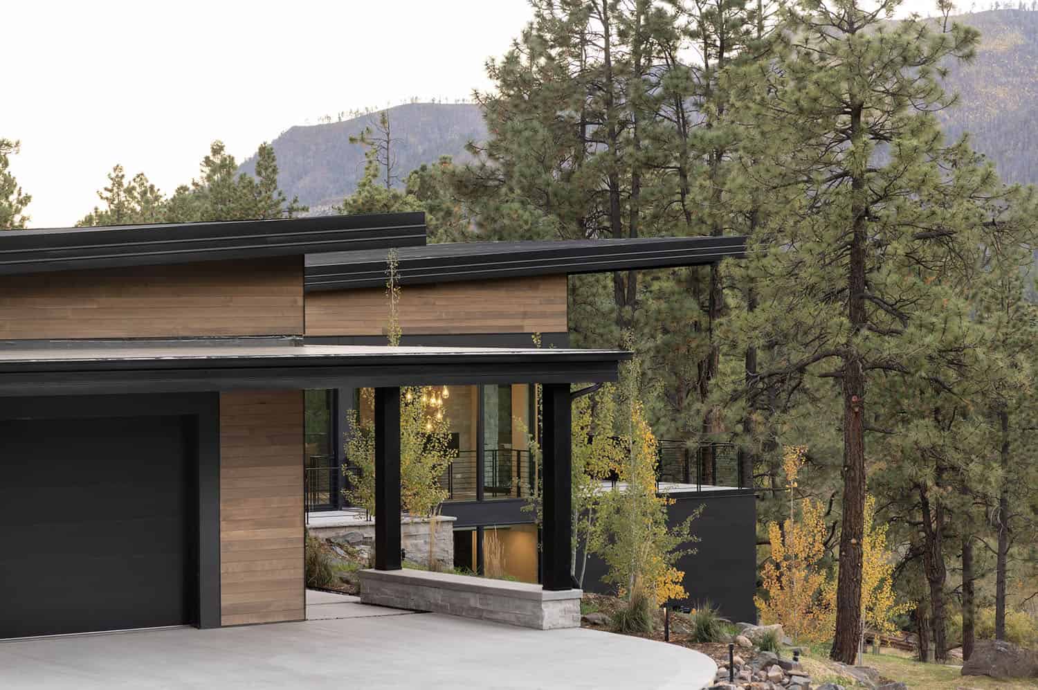 modern mountain home exterior with a backdrop of ponderosa pines