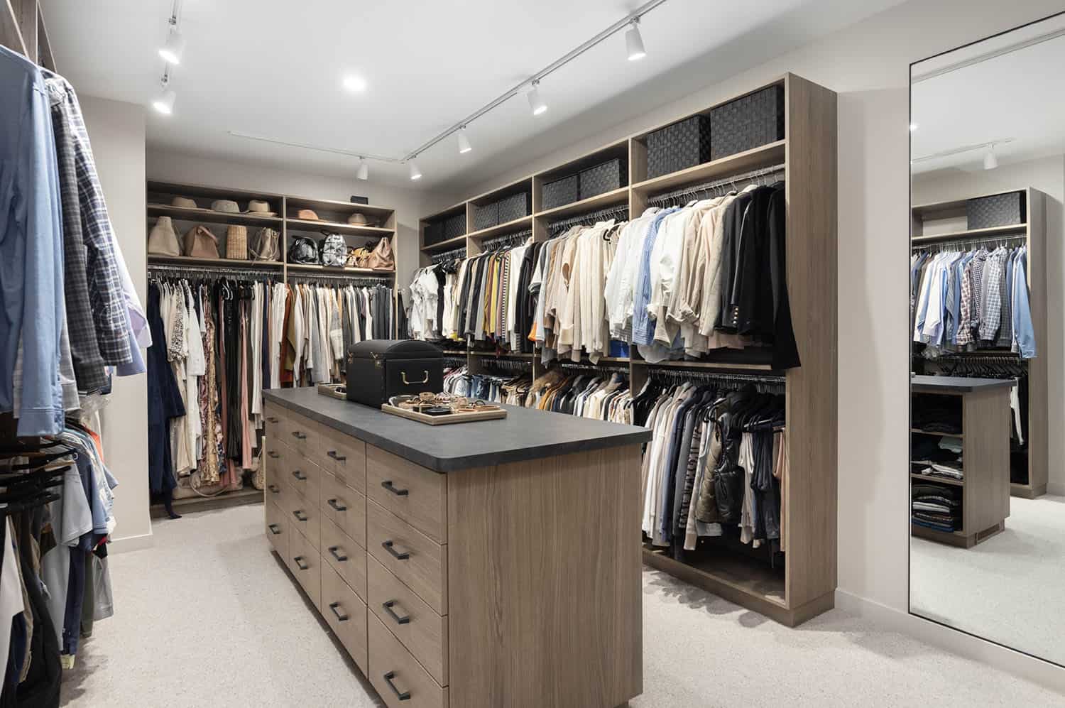 modern walk-in closet with a center storage cabinet