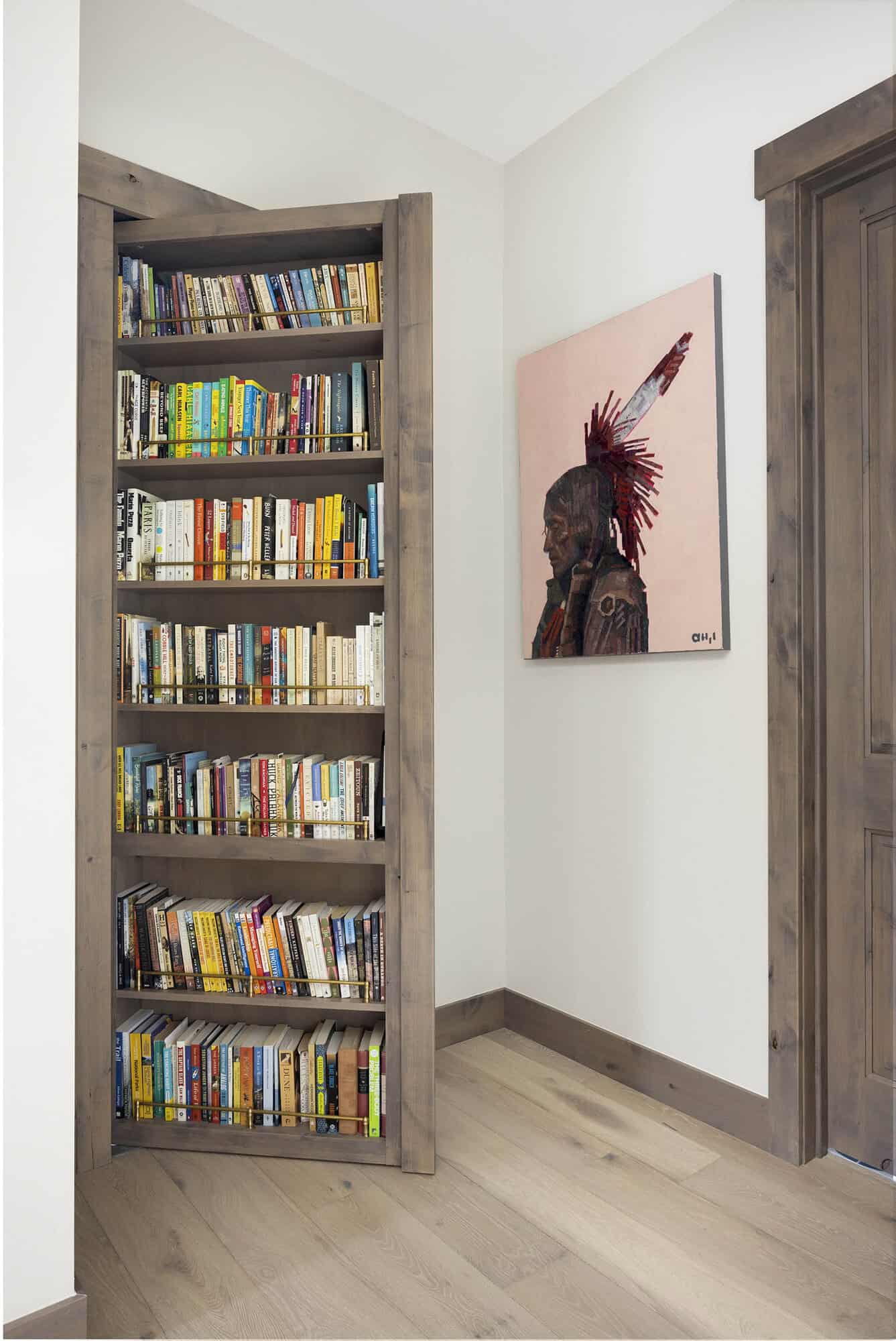 contemporary hallway with a bookcase and secret door