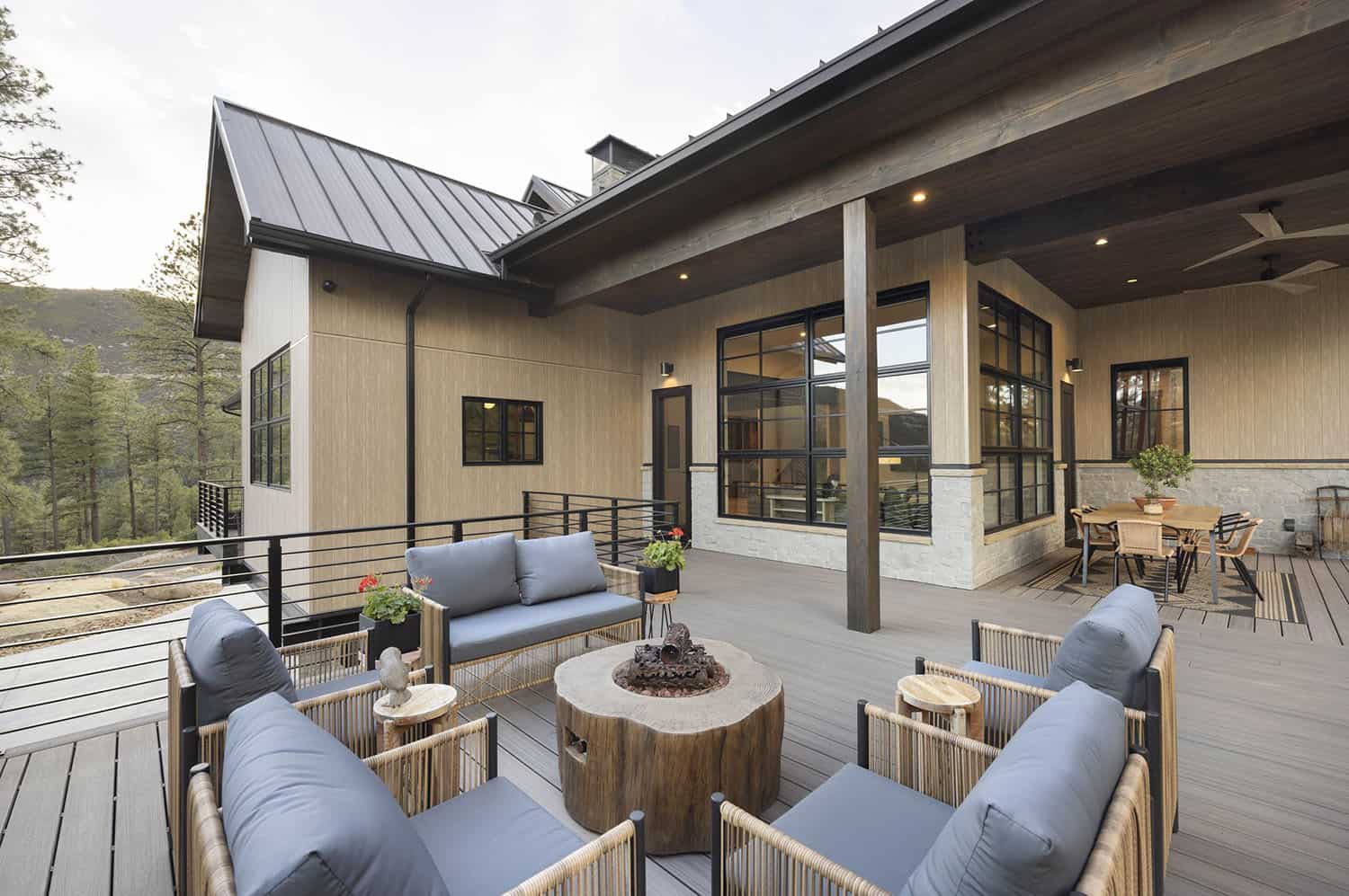 modern mountain home exterior with a deck and outdoor furniture