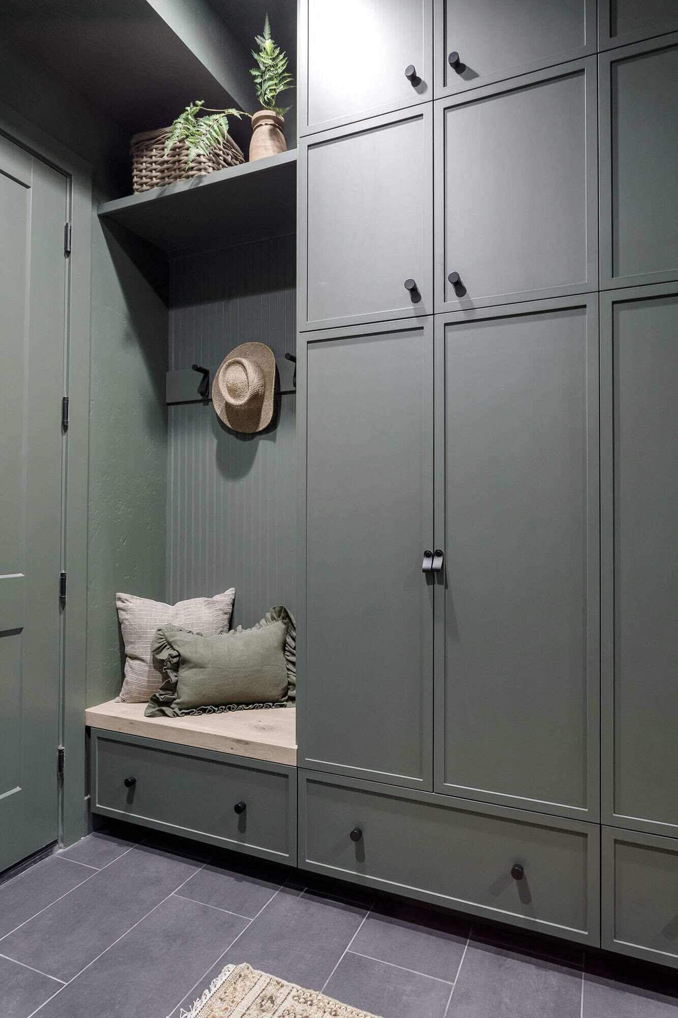 Mudroom with green built-in cabinets and a bench