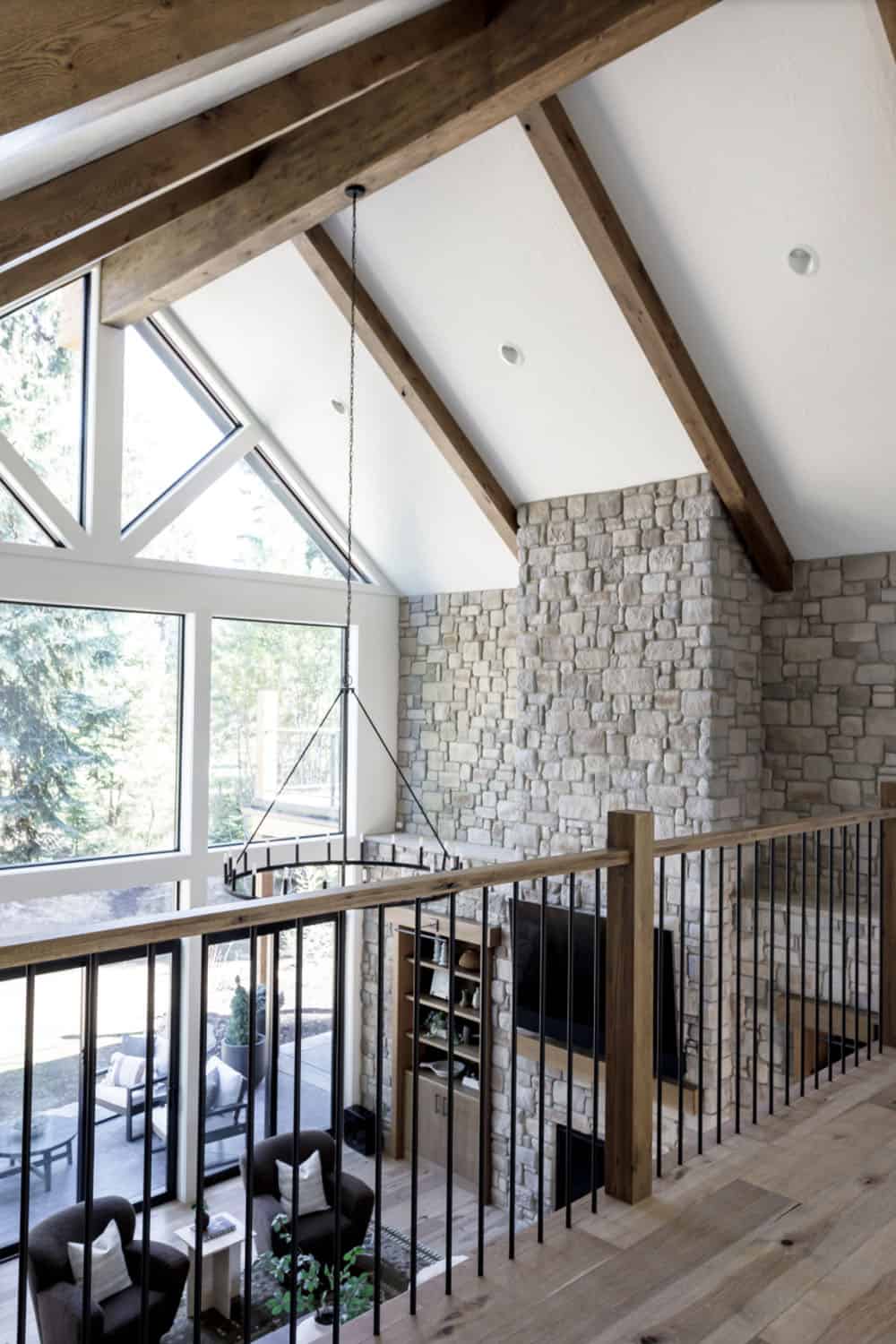 two-story great room, with a window wall and fireplace wall of stone