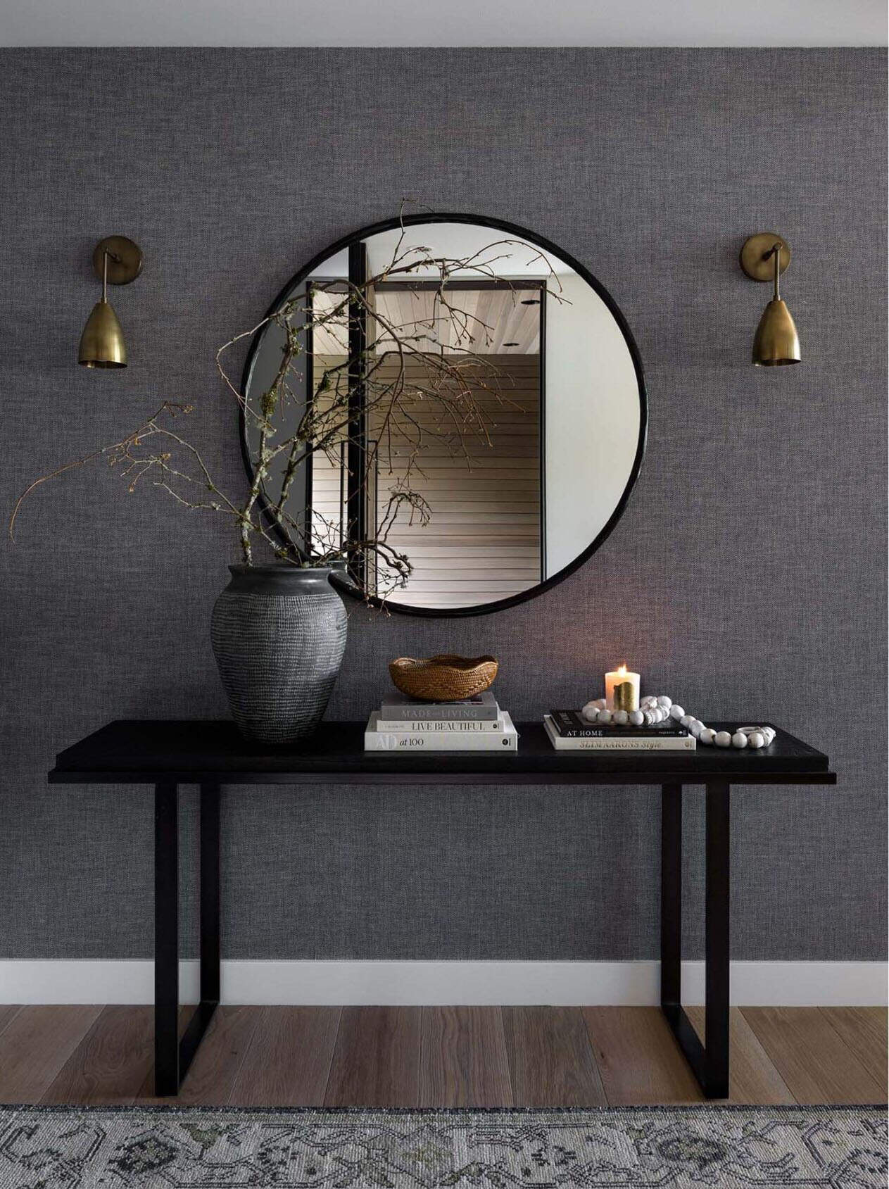modern home entry with a console table and round mirror