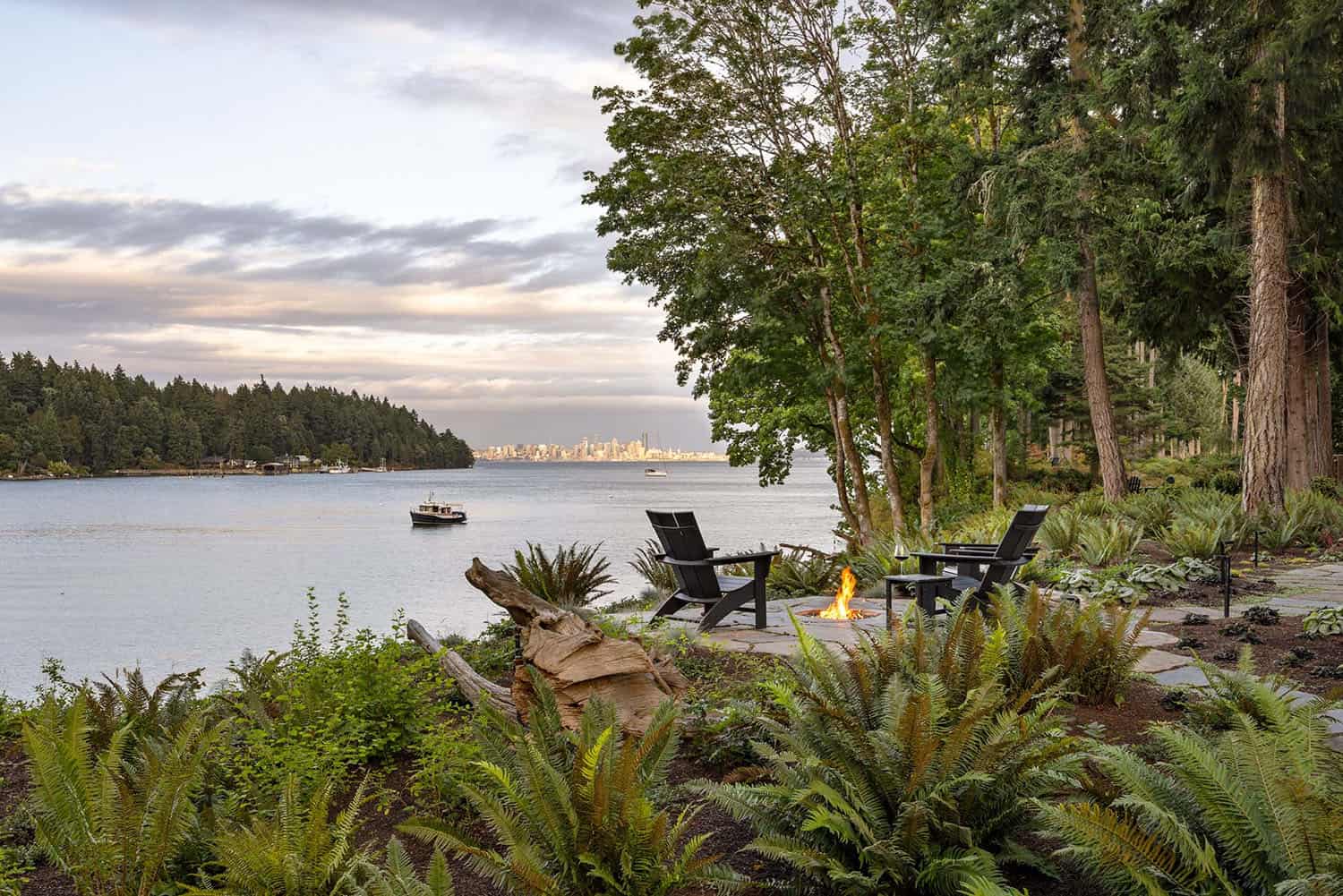 modern house exterior with a fire pit and water views