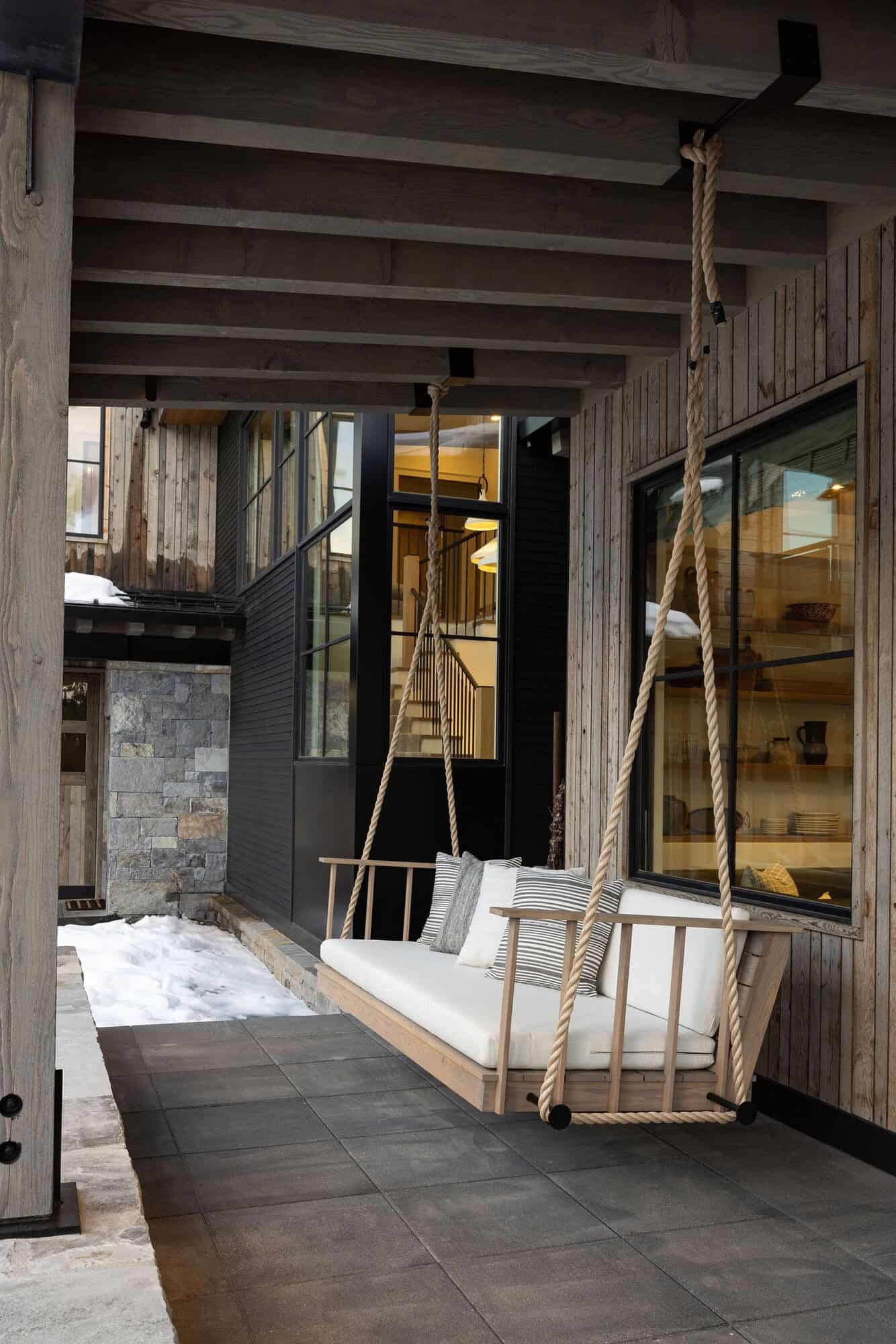 modern farmhouse style covered porch with a hanging swing