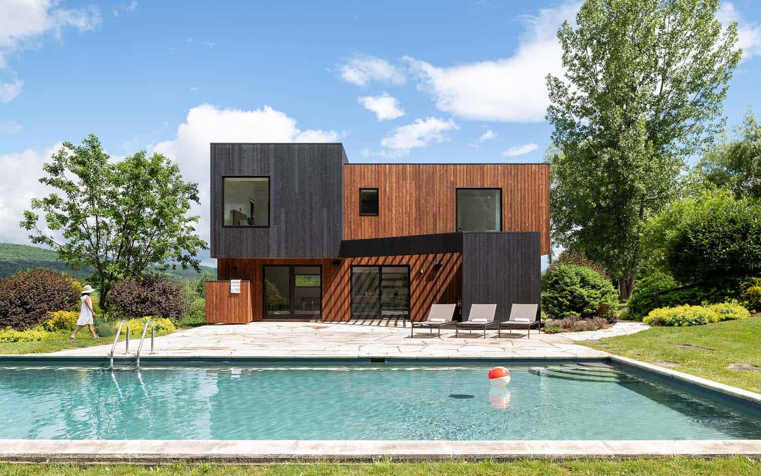 A modern home with wooden siding and a pool