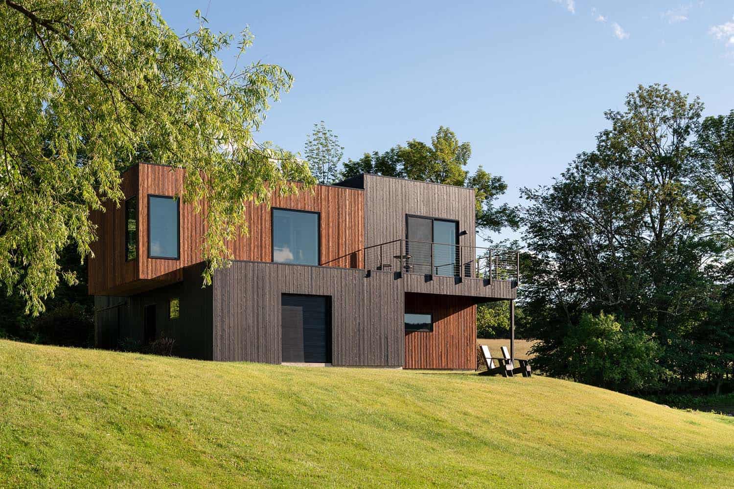 A modern house on a hillside with trees