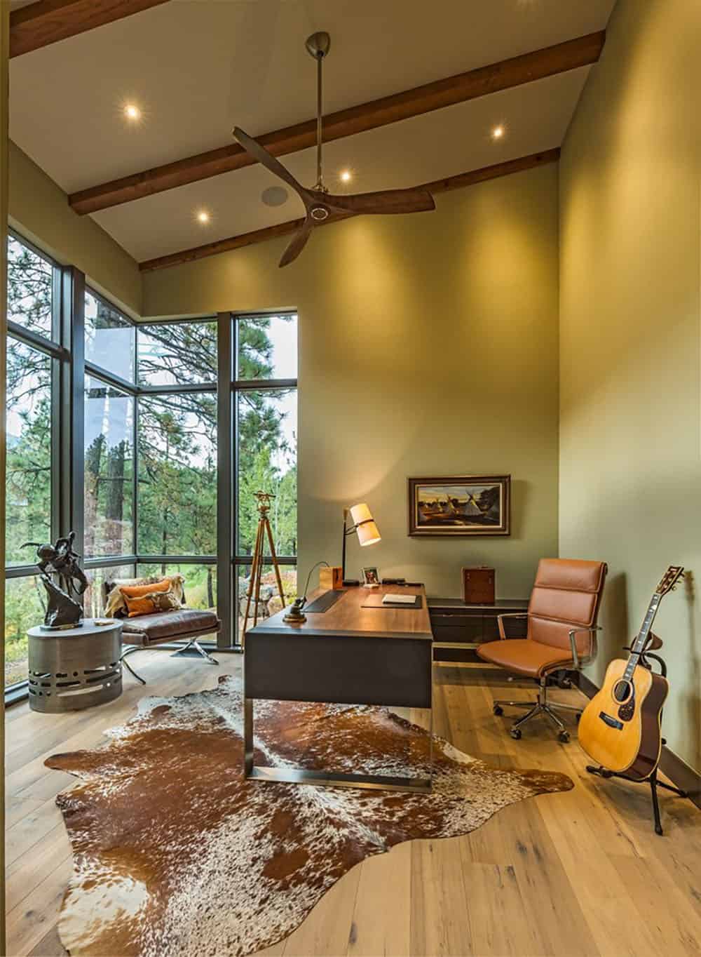 A home office with a cow hide rug and a guitar