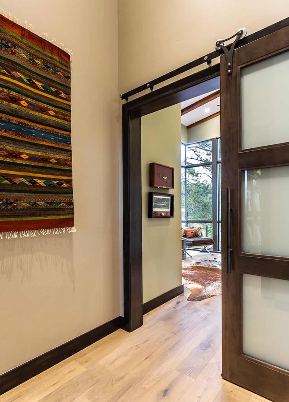 A hallway with a sliding door and a rug