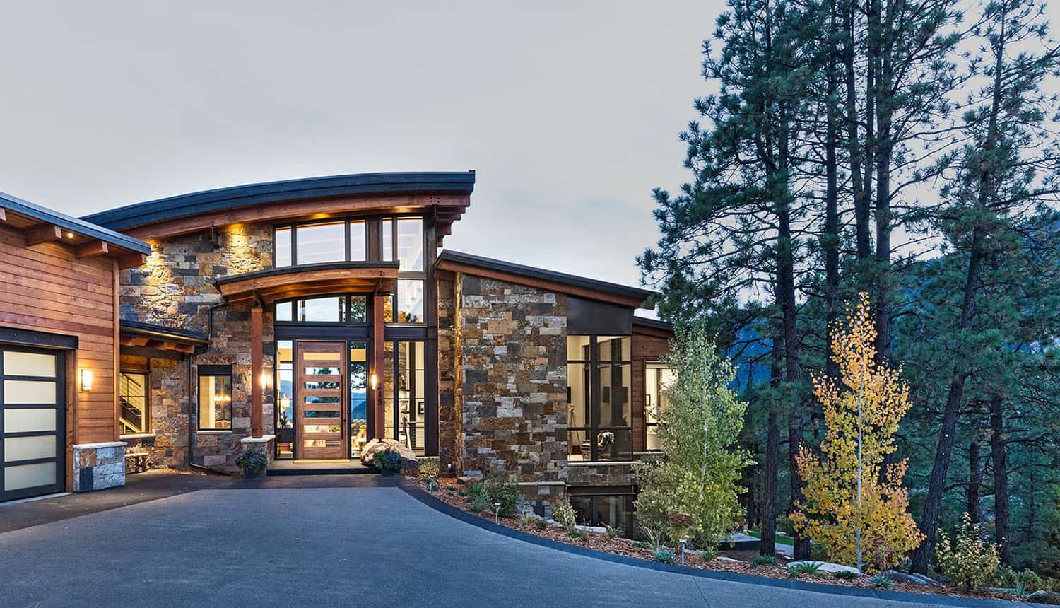 A modern mountain home with a driveway and garage