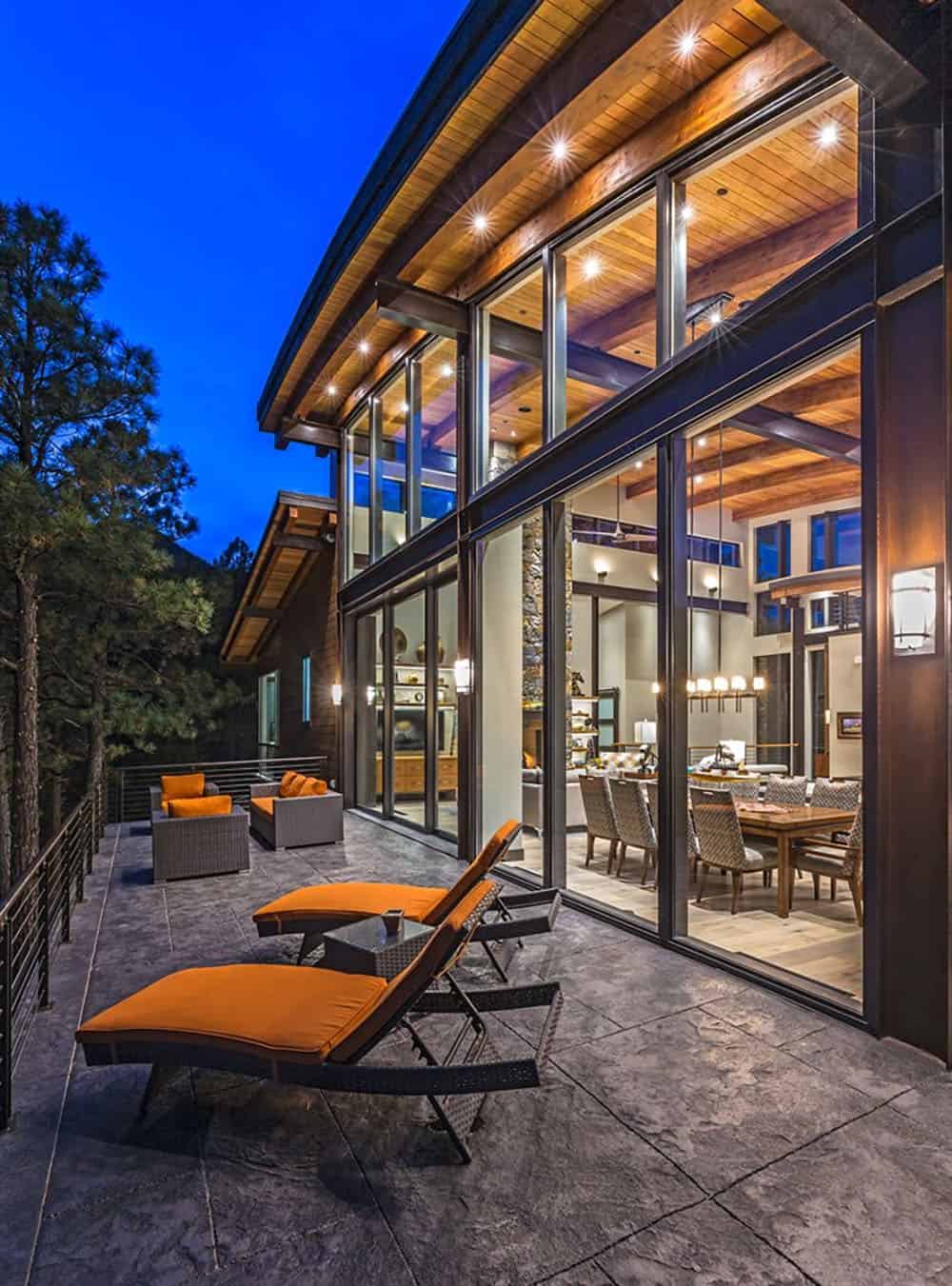 A patio with lounge chairs and a large glass door