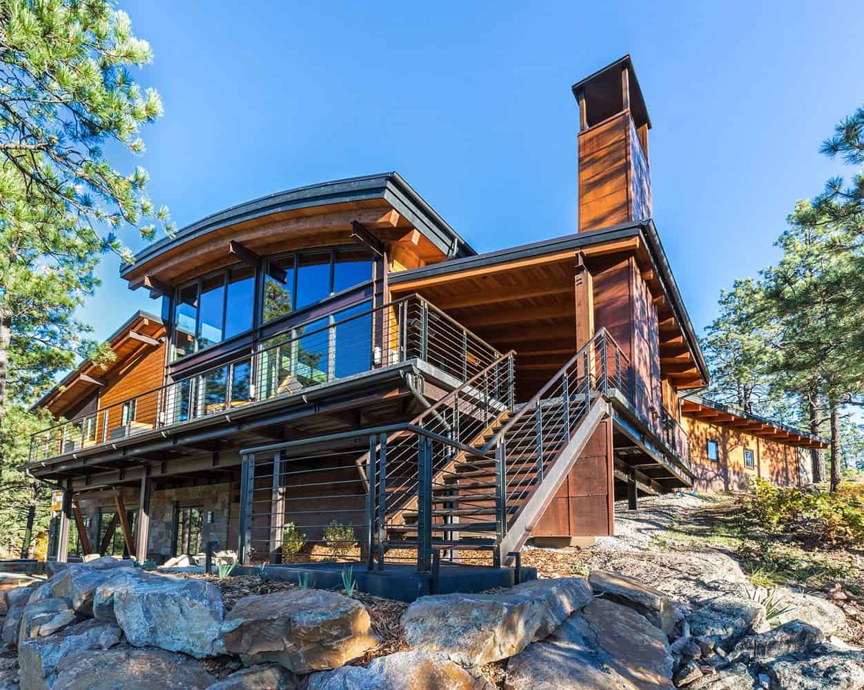 A modern mountain home with a large deck