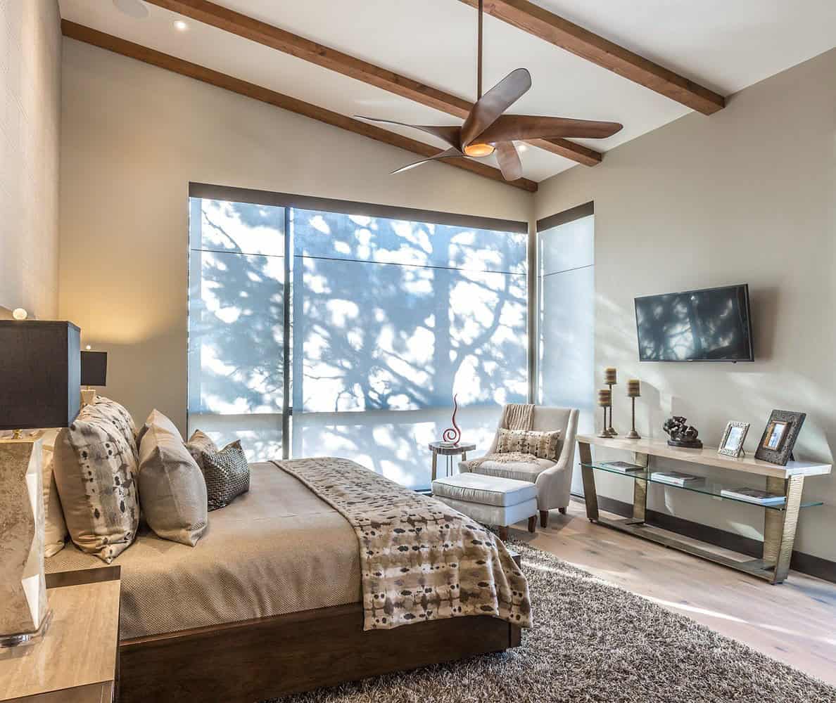 A bedroom with a ceiling fan and a bed