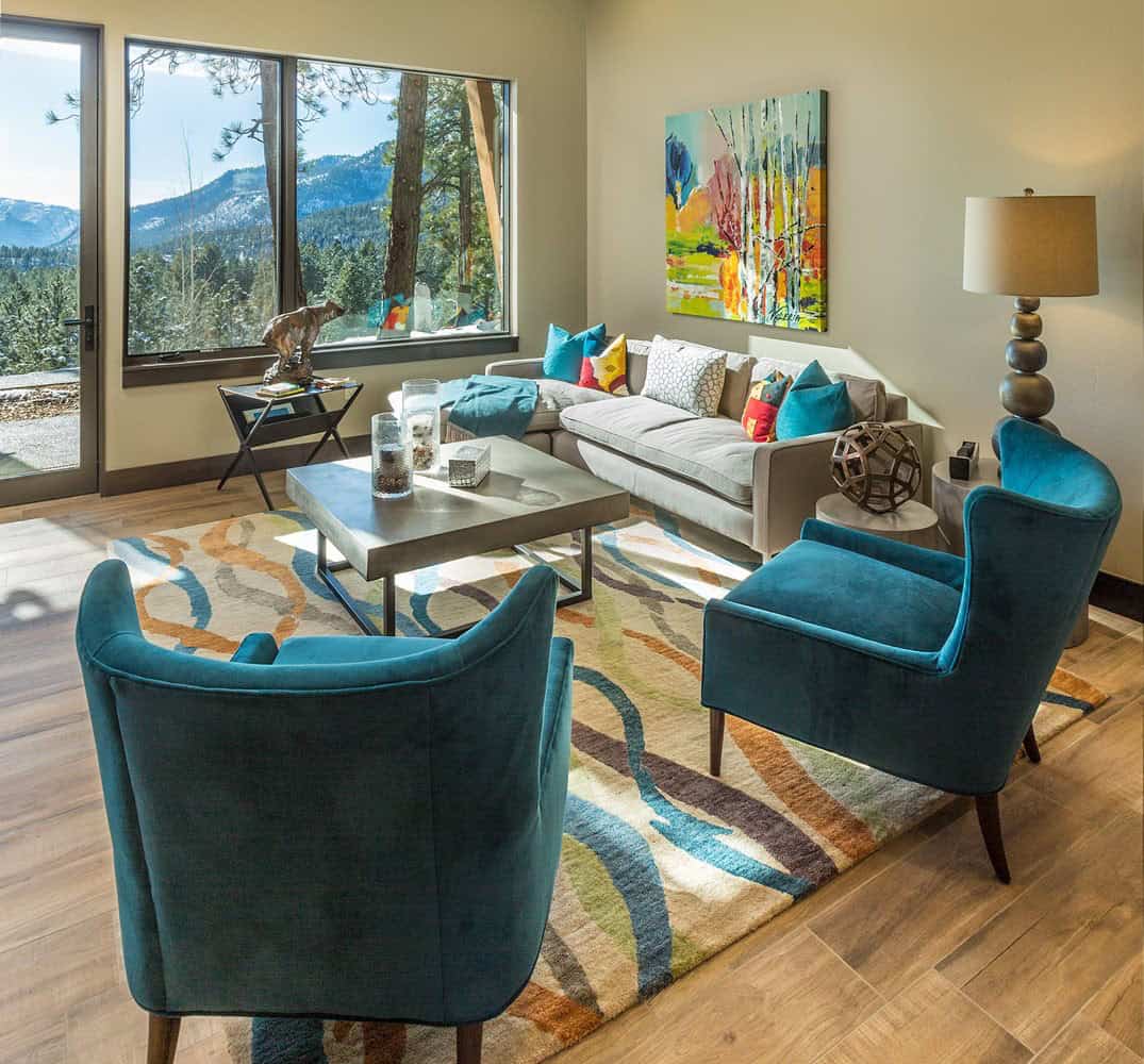 A family room with blue chairs and a view of the mountains