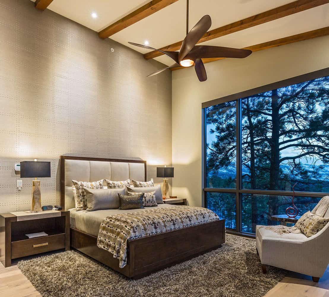 A bedroom with a ceiling fan and a bed