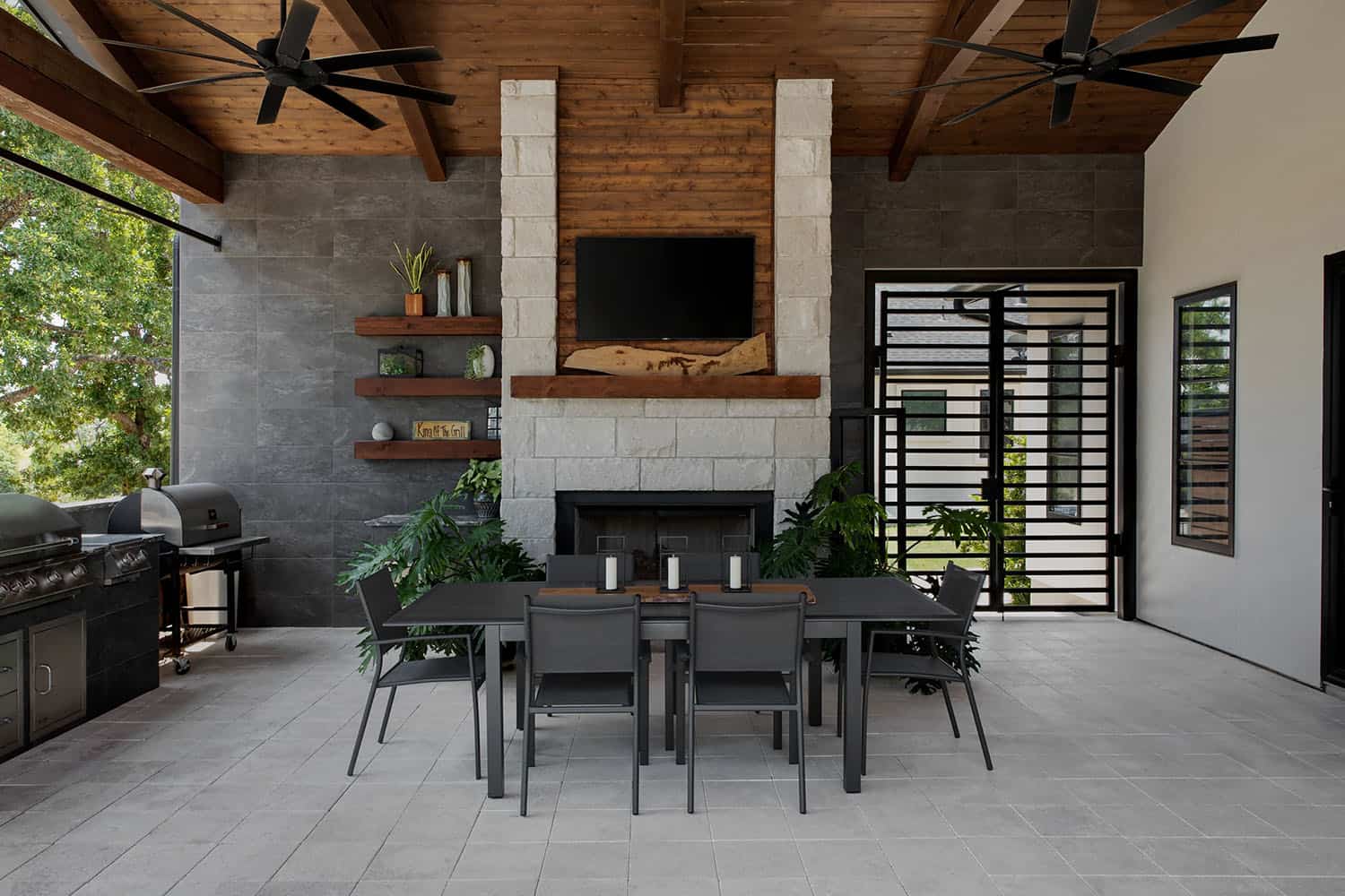 organic modern home covered patio with alfresco dining and a fireplace