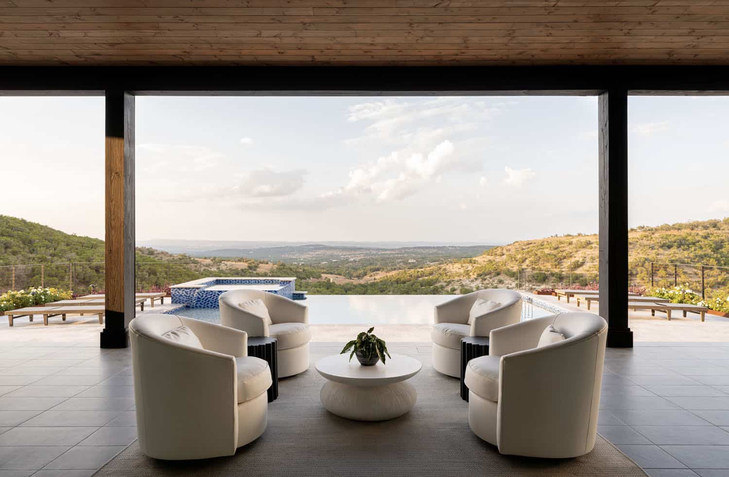 farmhouse style home exterior covered patio with a view of the pool and texas hill country