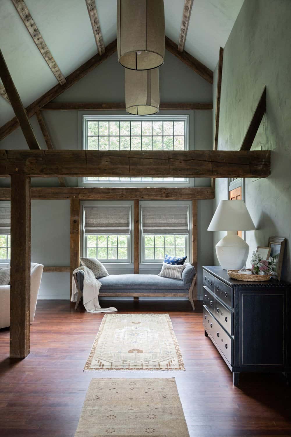 contemporary bedroom with rustic wood beams and tall ceiling