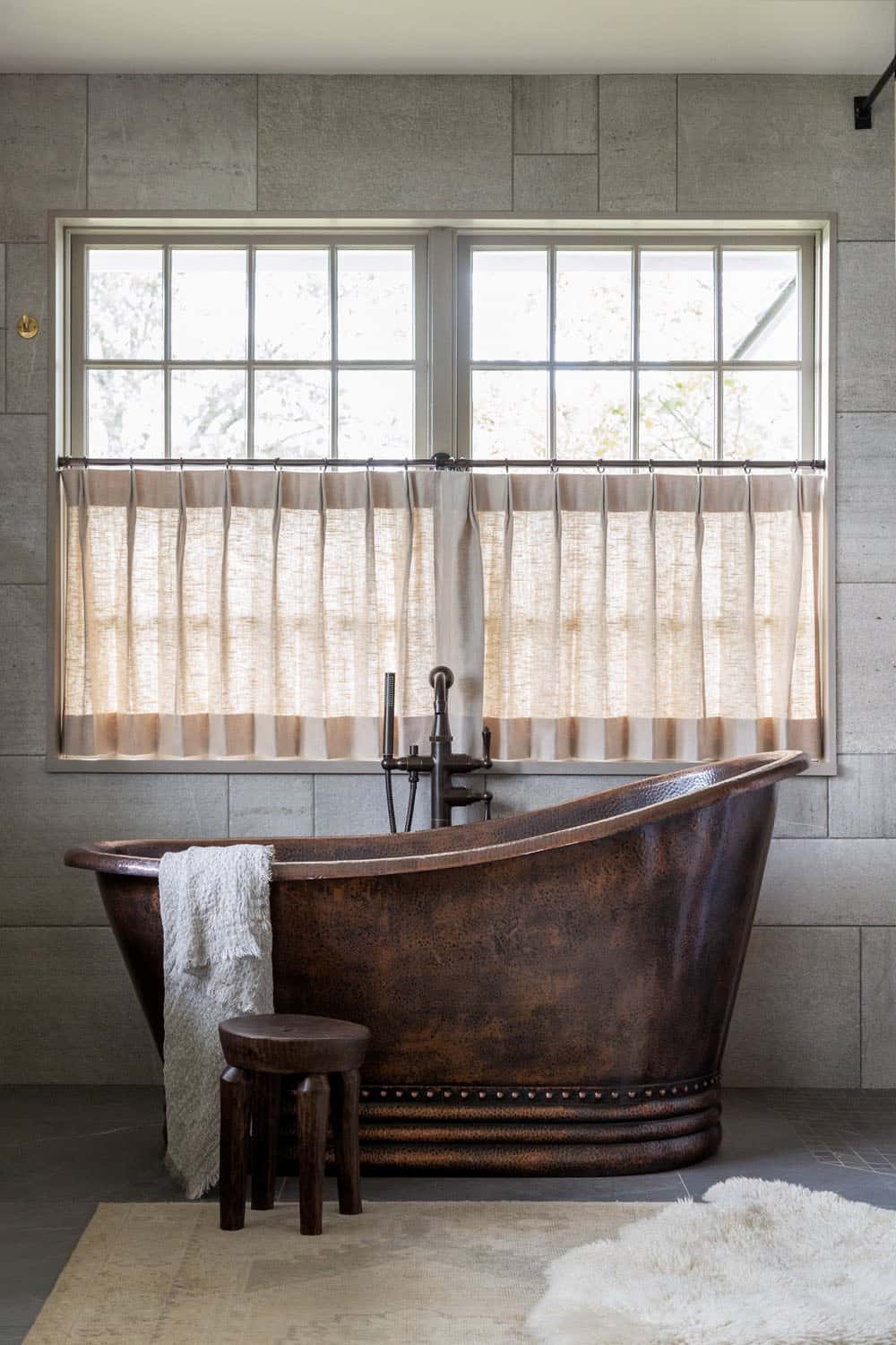 contemporary bathroom with a copper tub and a large window