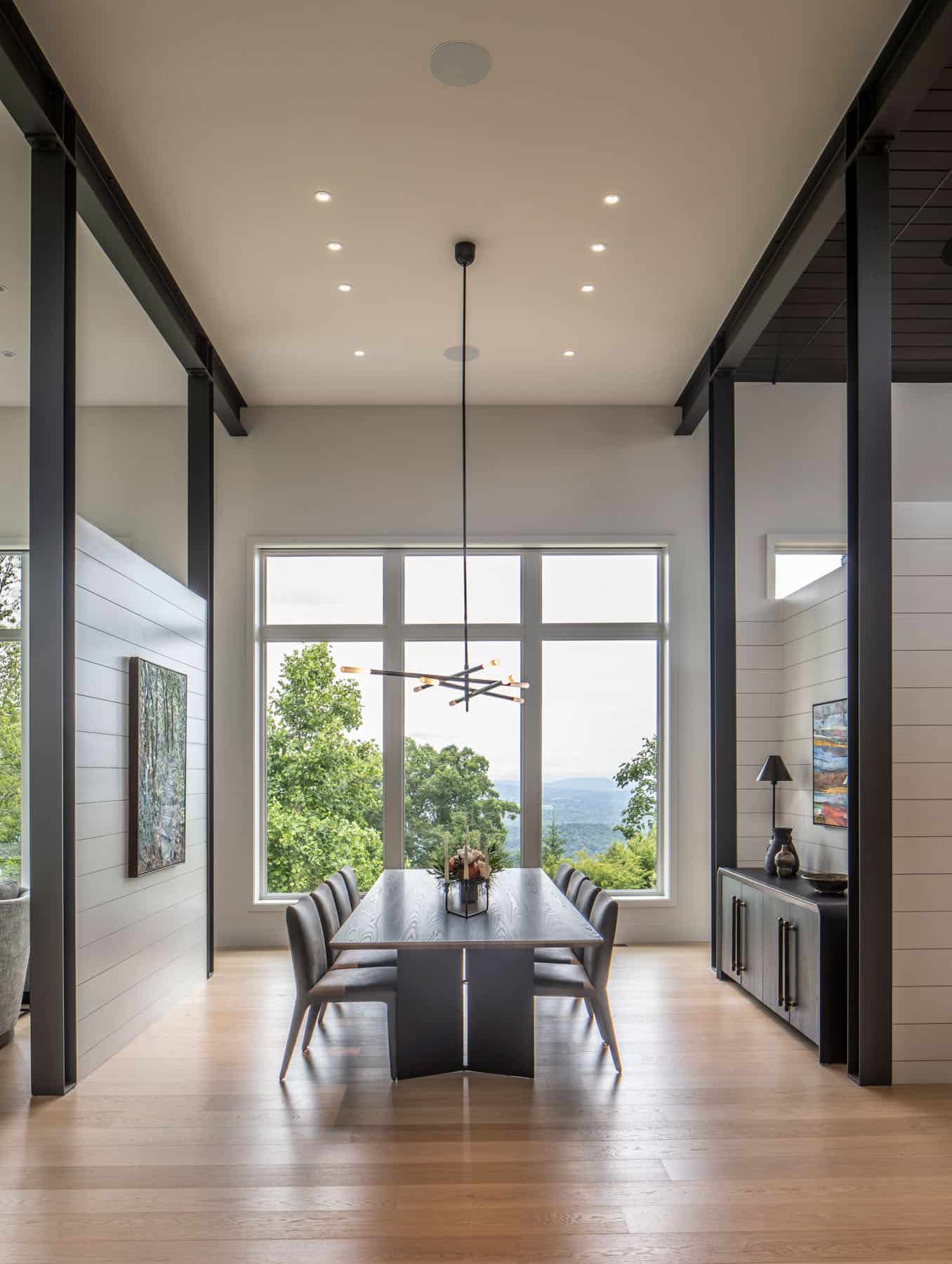 modern dining room with a chandelier and large windows