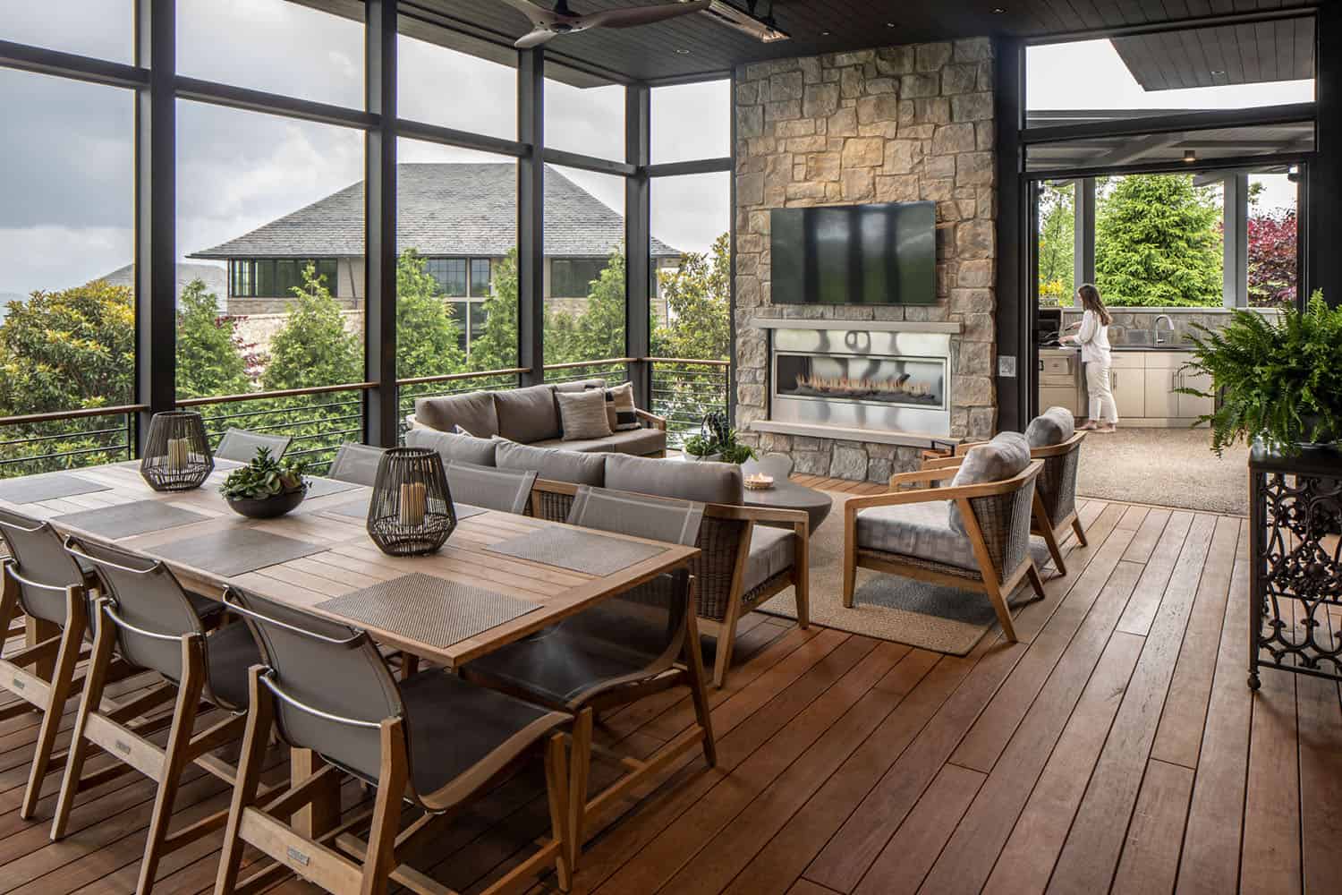 modern screened porch with dining and living area and a fireplace