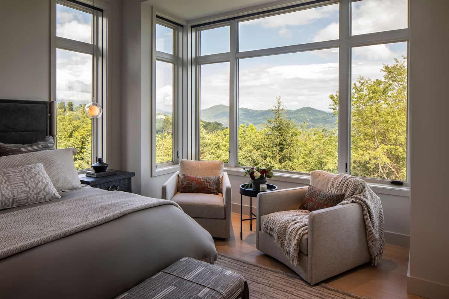 modern bedroom with large windows and mountain views