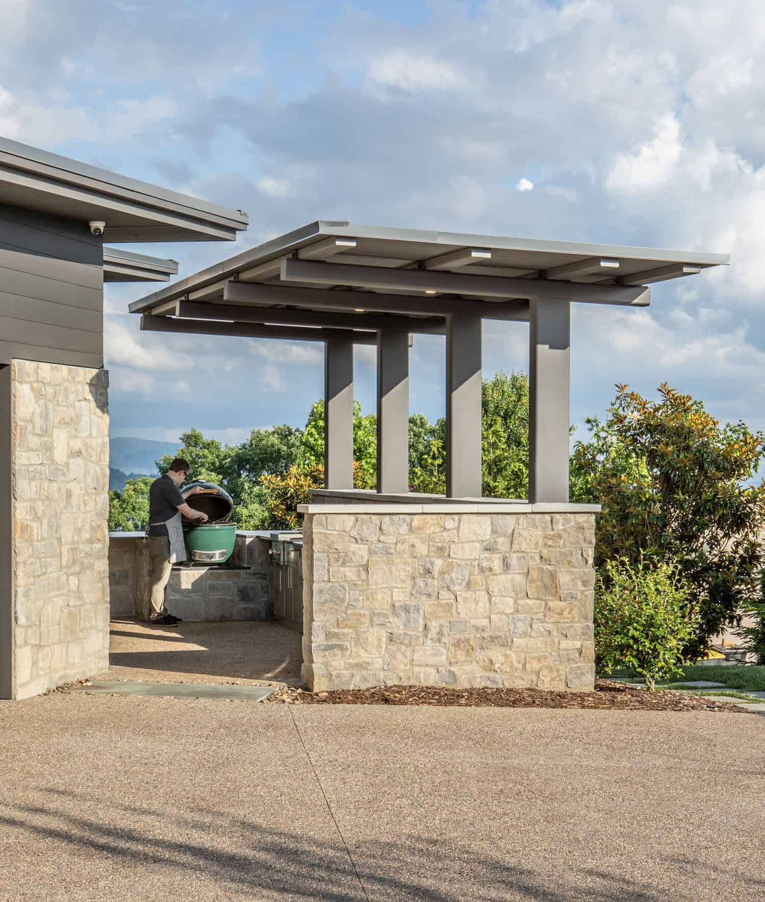 mountain modern home exterior with a pergola covered outdoor grill