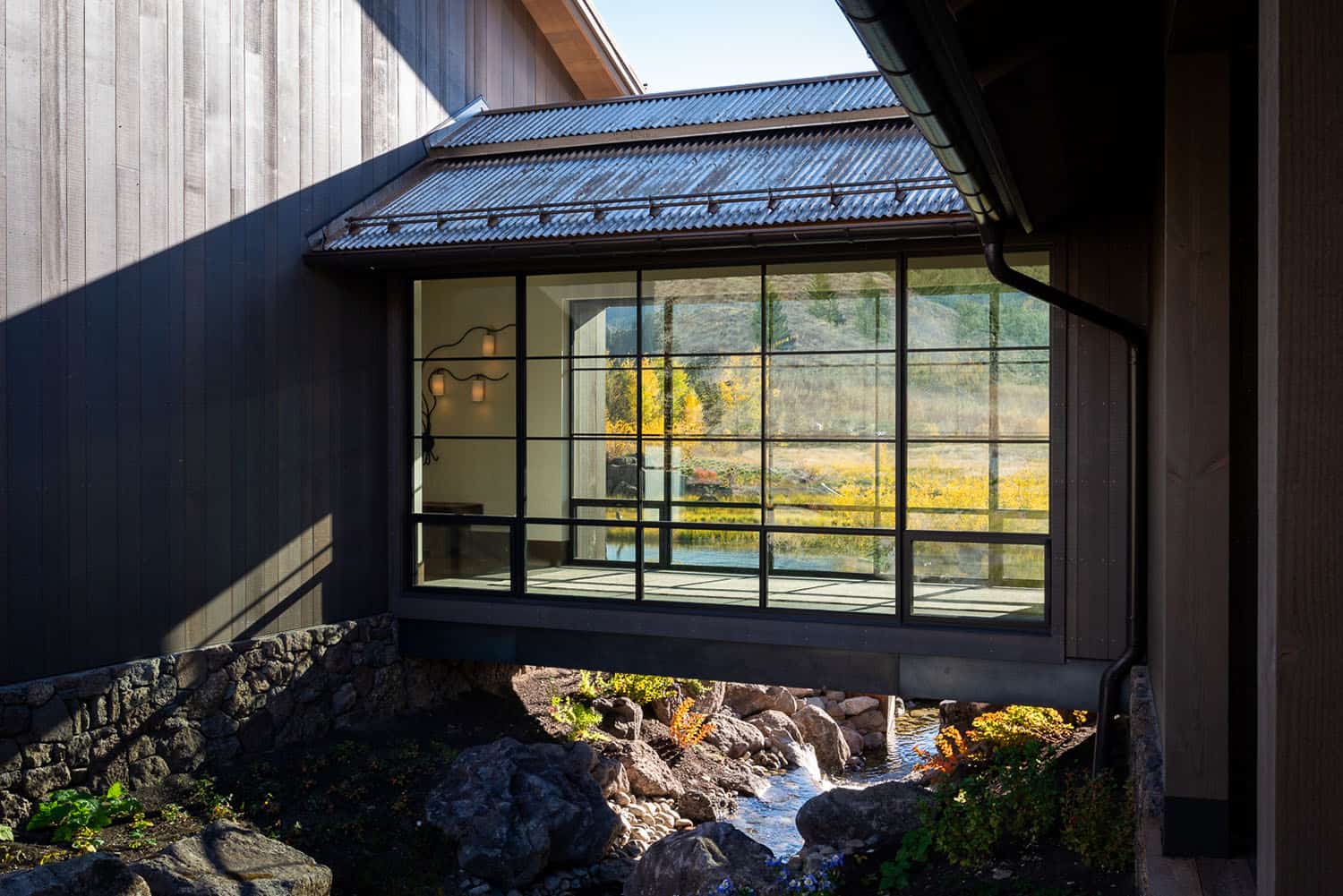 modern mountain home exterior with a glass bridge connection