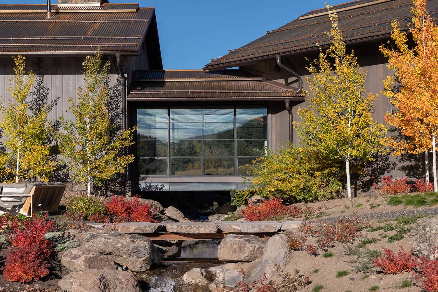 modern mountain home exterior with a glass bridge connection