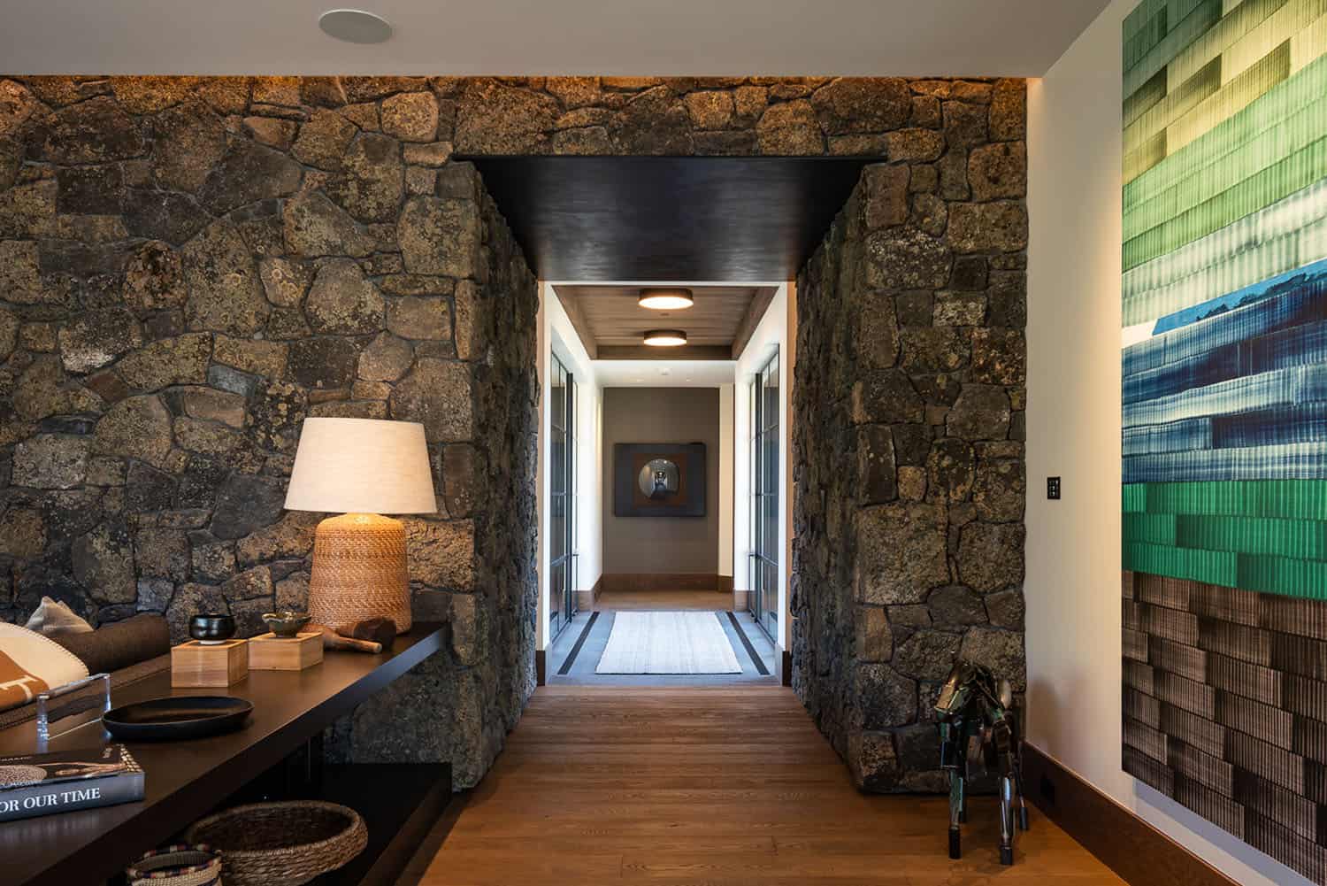 modern rustic hallway with a stone wall