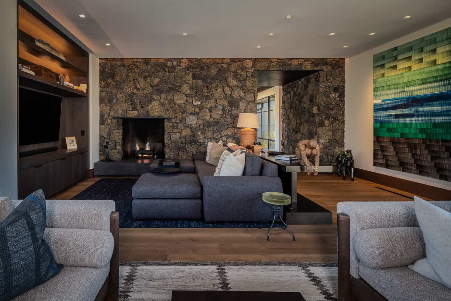 modern rustic living room with a stone wall and fireplace