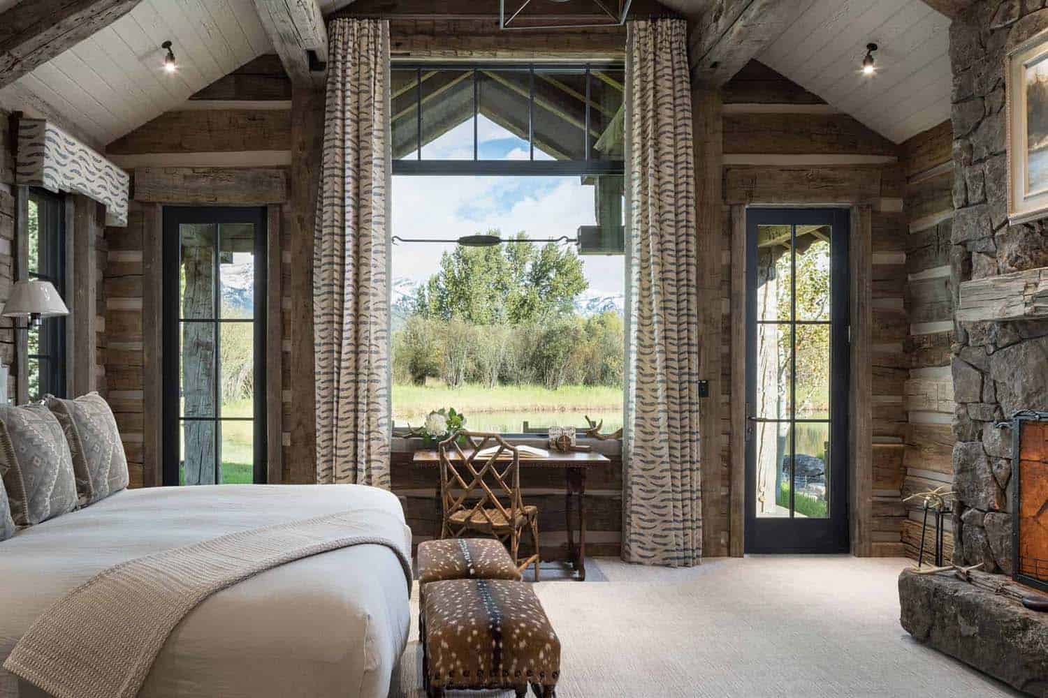 A rustic bedroom with a stone fireplace and a bed