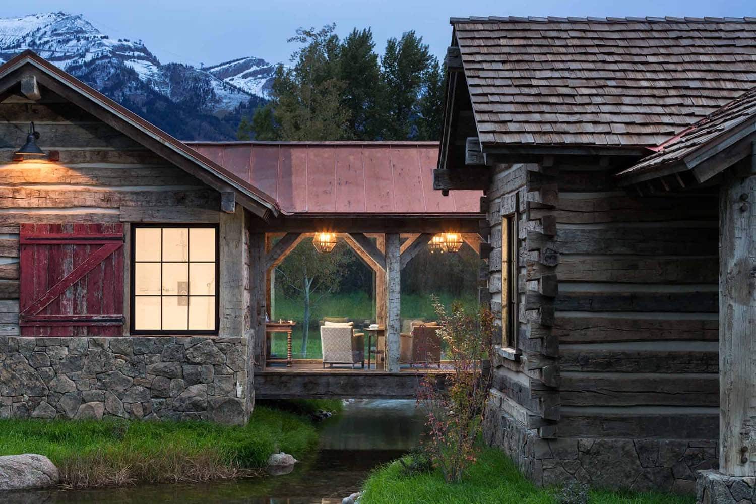 A rustic log home with a stream running through it