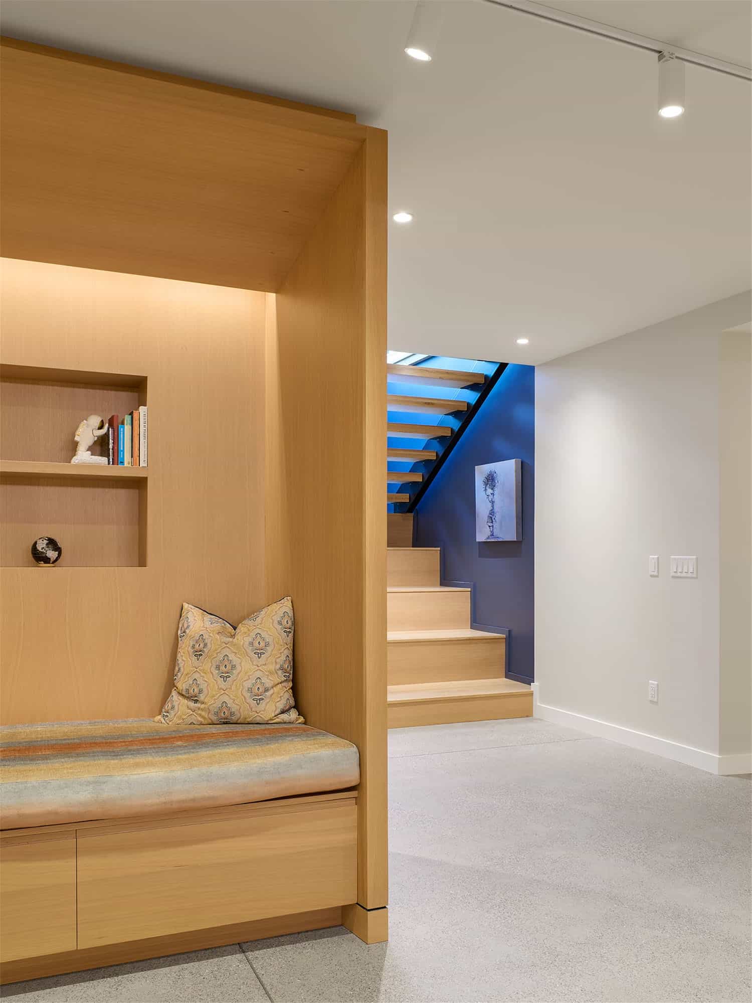 modern staircase to basement level with a built-in bench seat