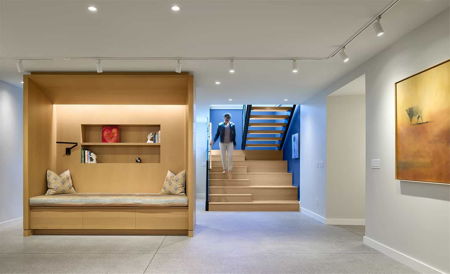 modern staircase to basement level with a built-in bench seat