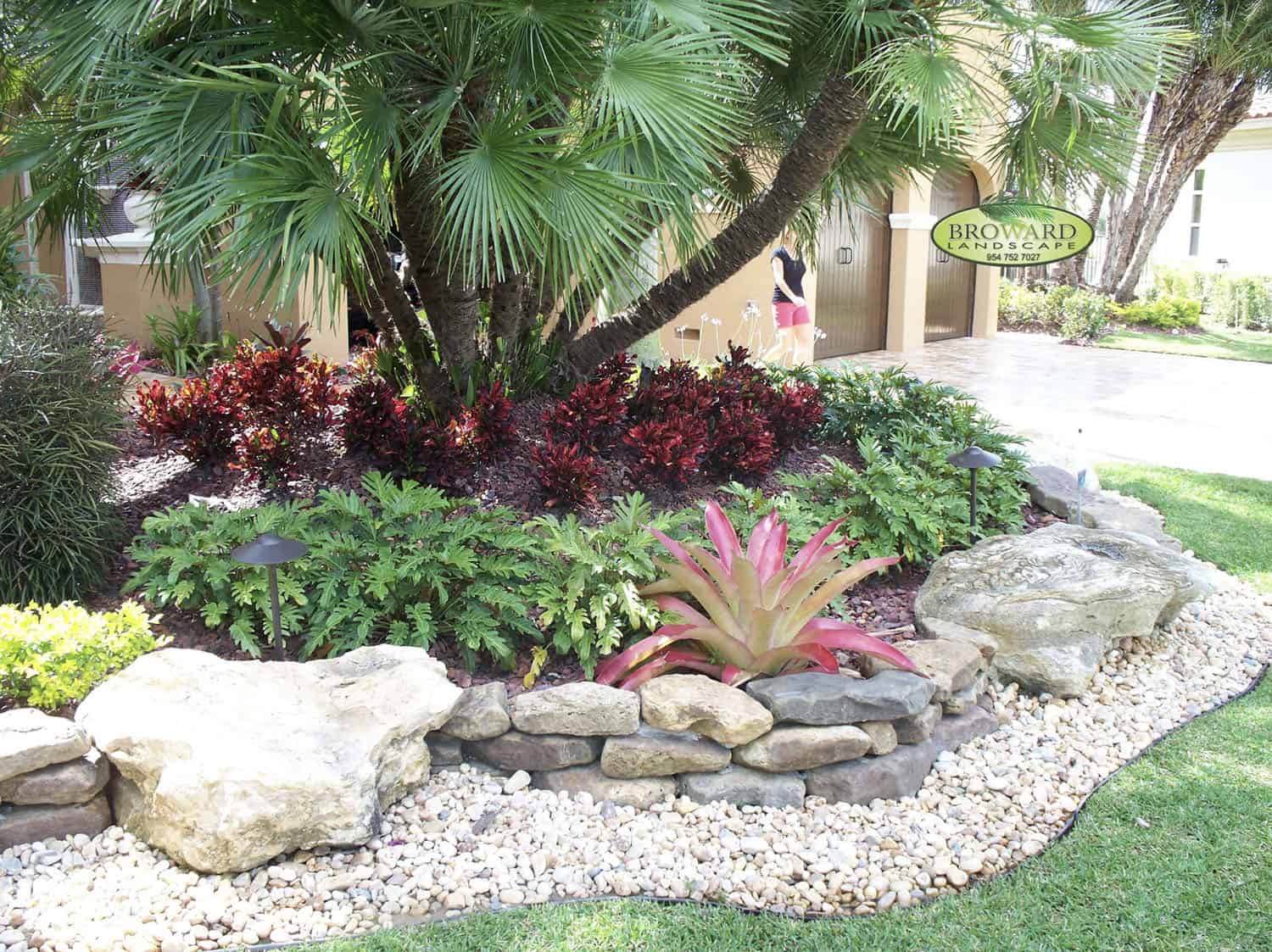 front yard with a flower bed surrounding a large tree