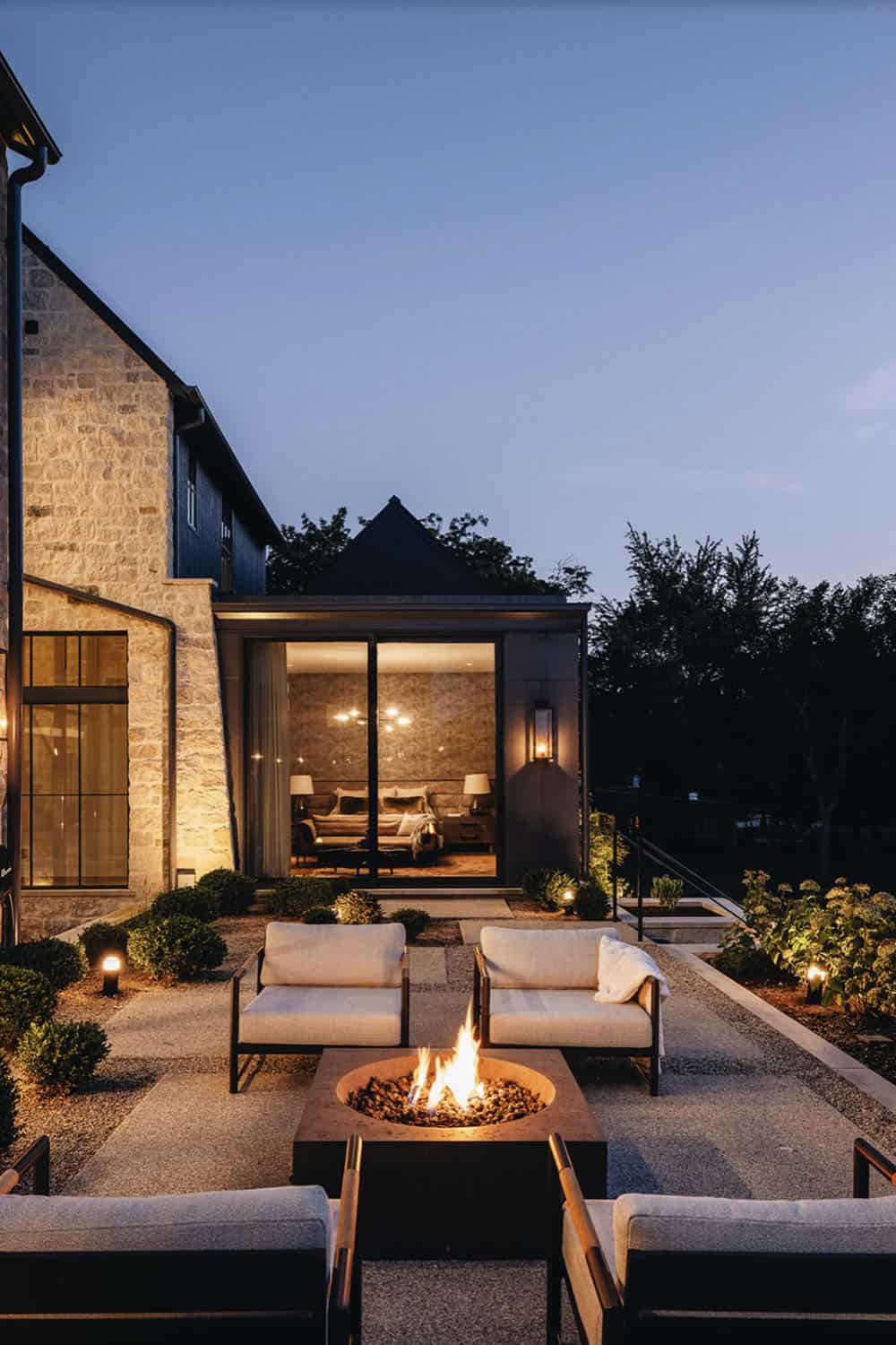 transitional home exterior patio with a fire pit at dusk