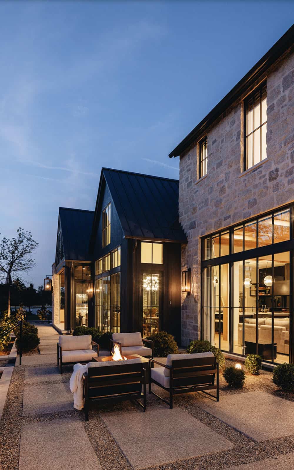 transitional home exterior patio with a fire pit at dusk