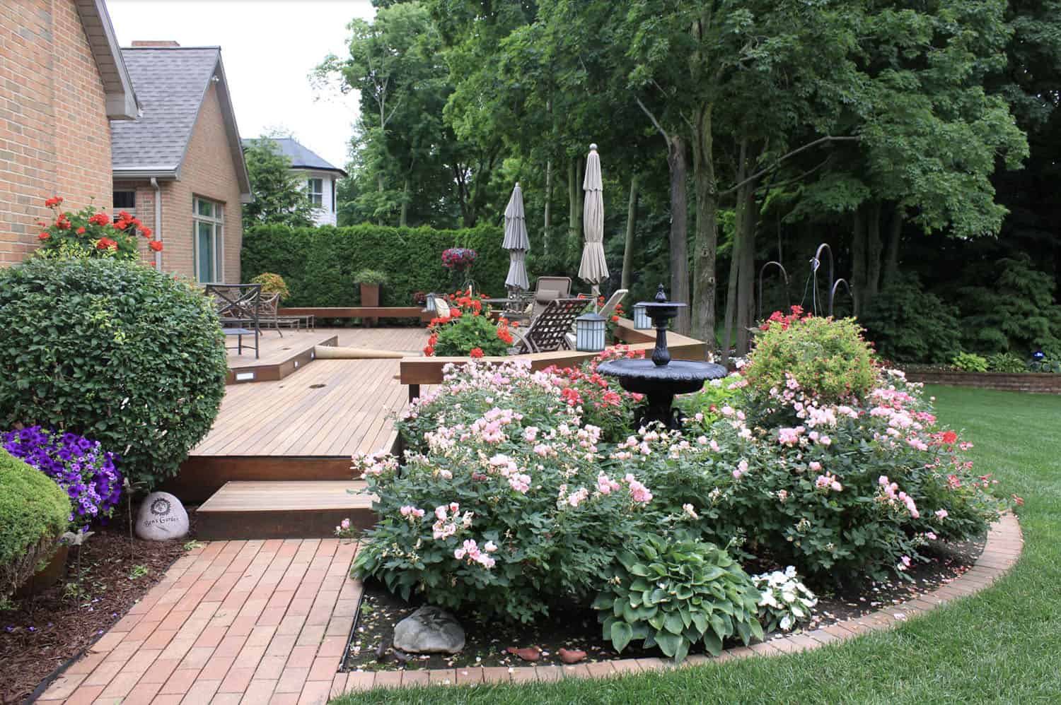 curved brick edging around a flower bed next to a large deck
